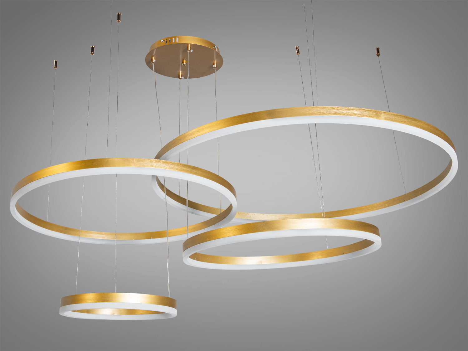 Підвісний світильник з чотирма золотими кільцями, що підходить для монтажу на стелі, створює елегантний акцент в інтер′єрі.