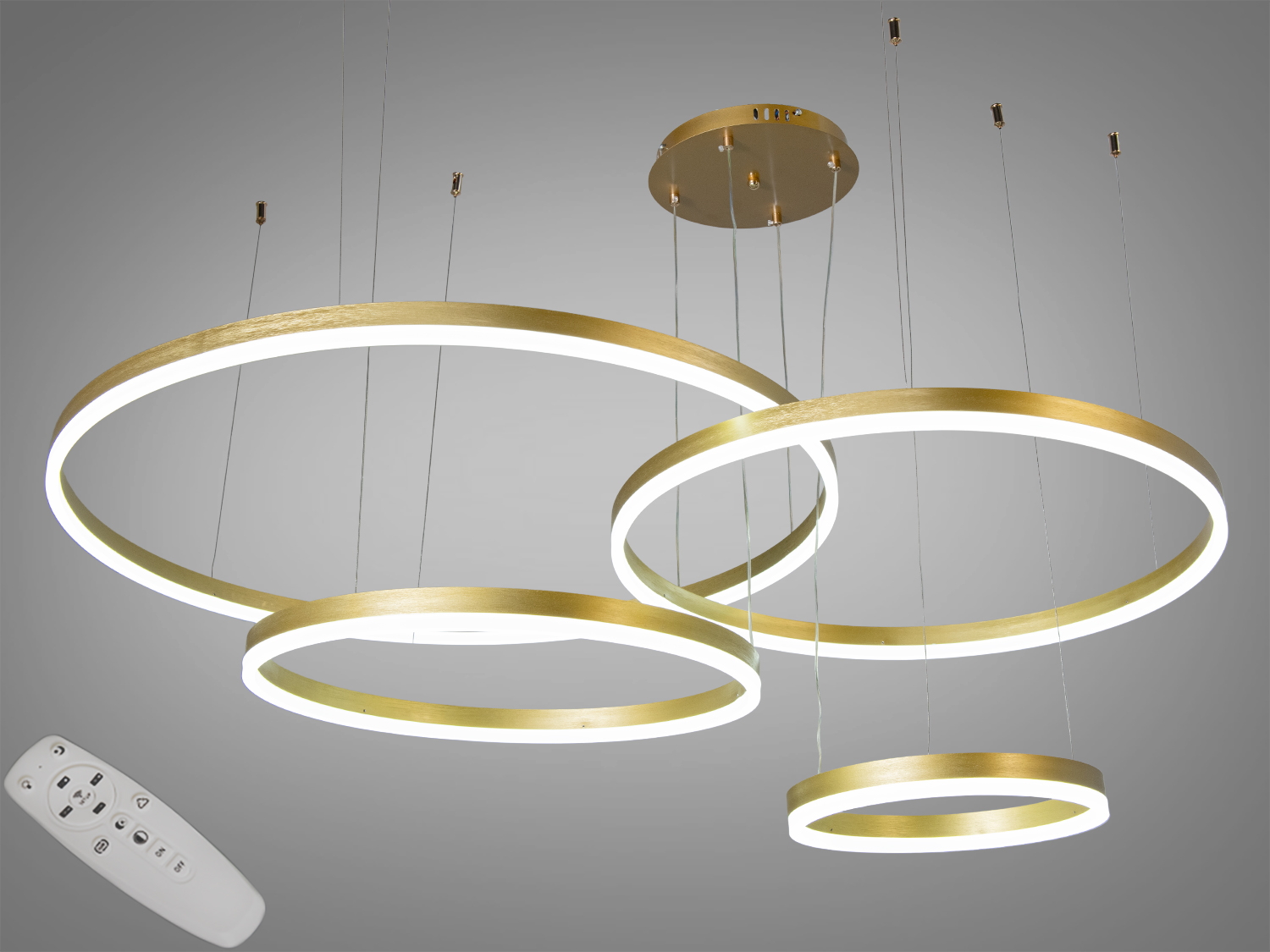 Підвісний світильник з чотирма золотими кільцями, що створює м′яке освітлення, підходить для вітальні або їдальні.