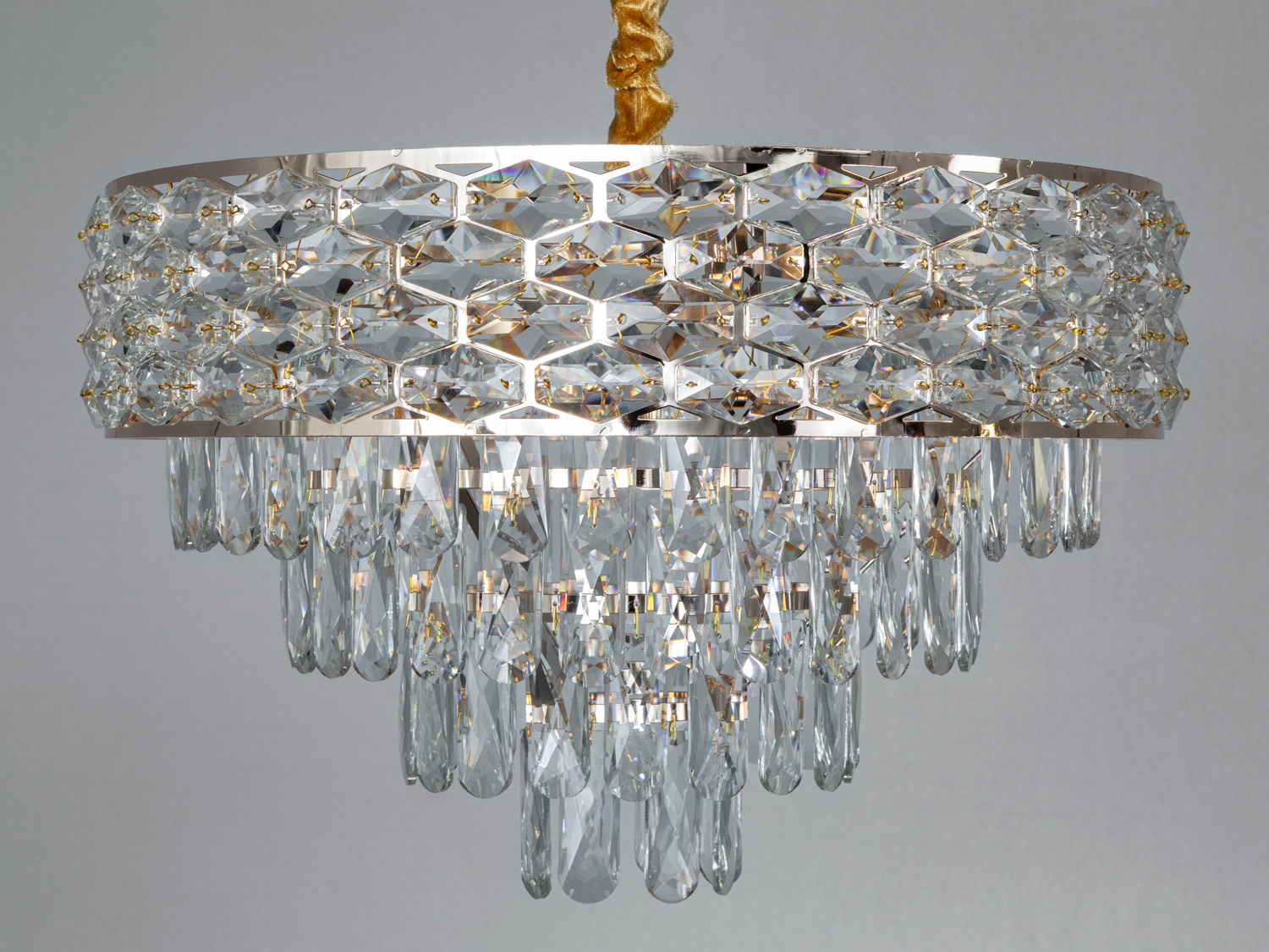 Верхній рівень люстри прикрашений прямокутними кришталевими пластинами, що створюють враження складної мозаїки.