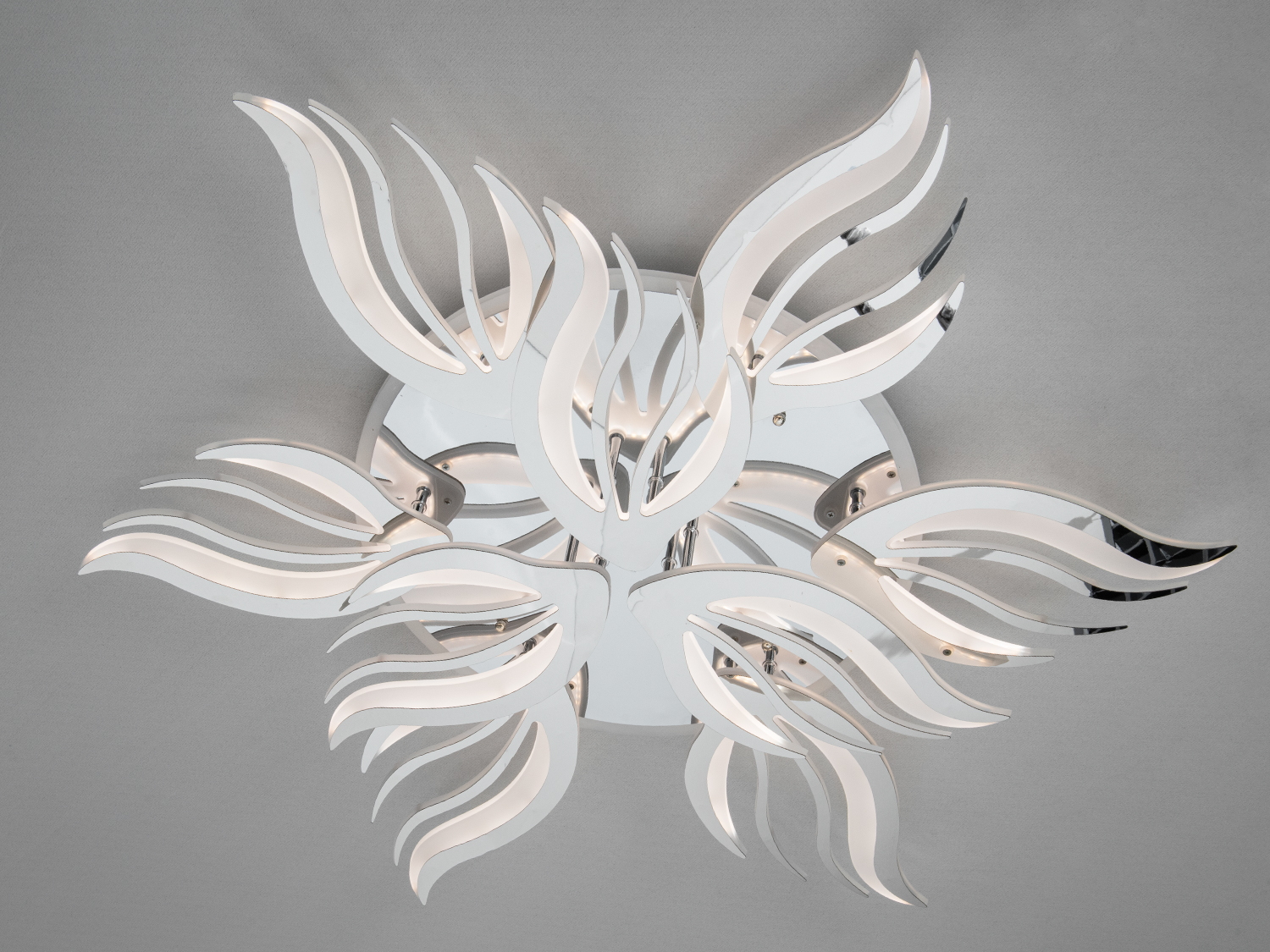 Стельовий світильник з хвилястими елементами, виконаний у білому кольорі, підходить для сучасного інтер’єру.