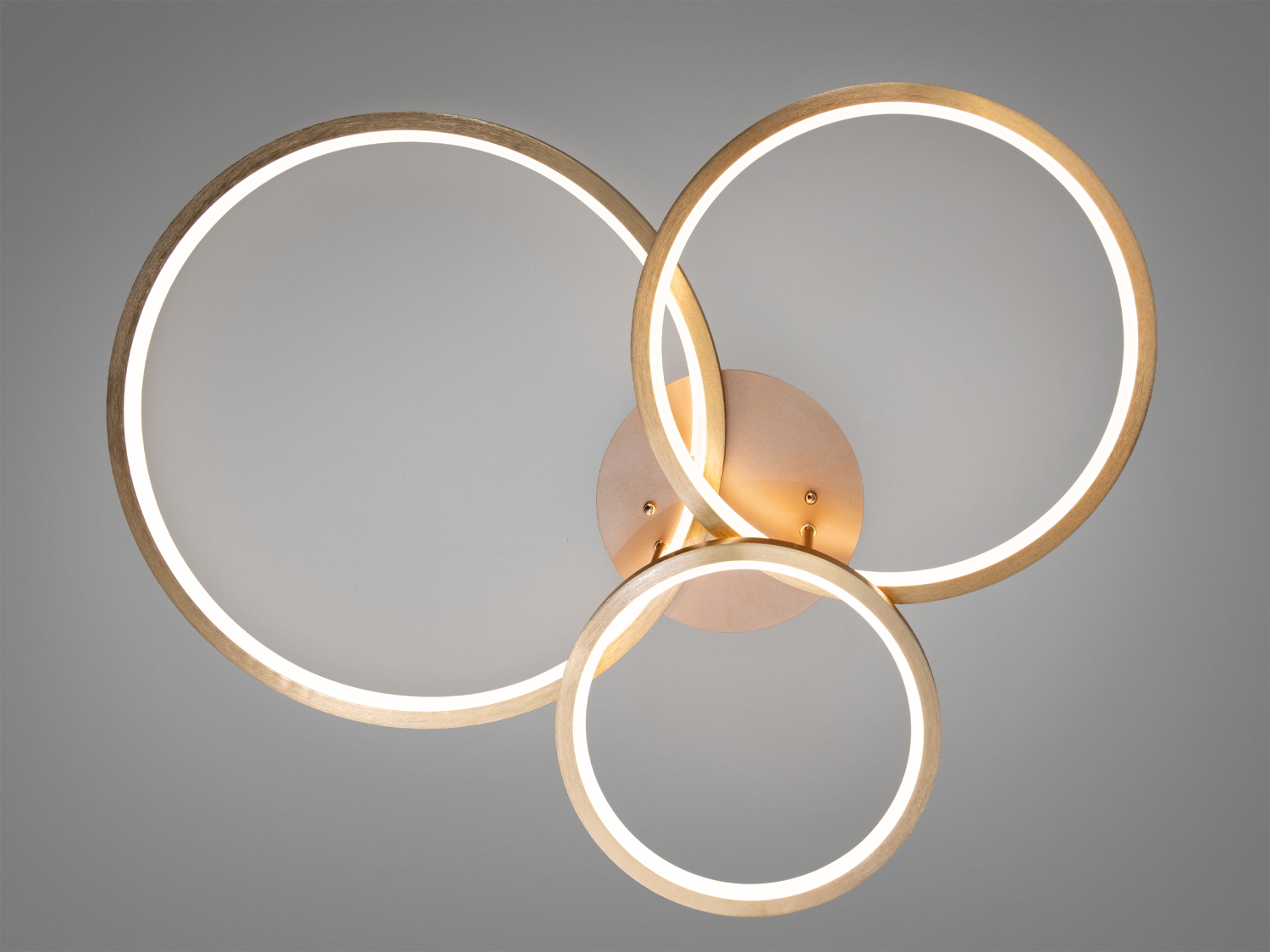 Стельовий світильник з трьома золотими кільцями, що перетинаються. Використовується для сучасного інтер’єру, створюючи м’яке розсіяне світло.