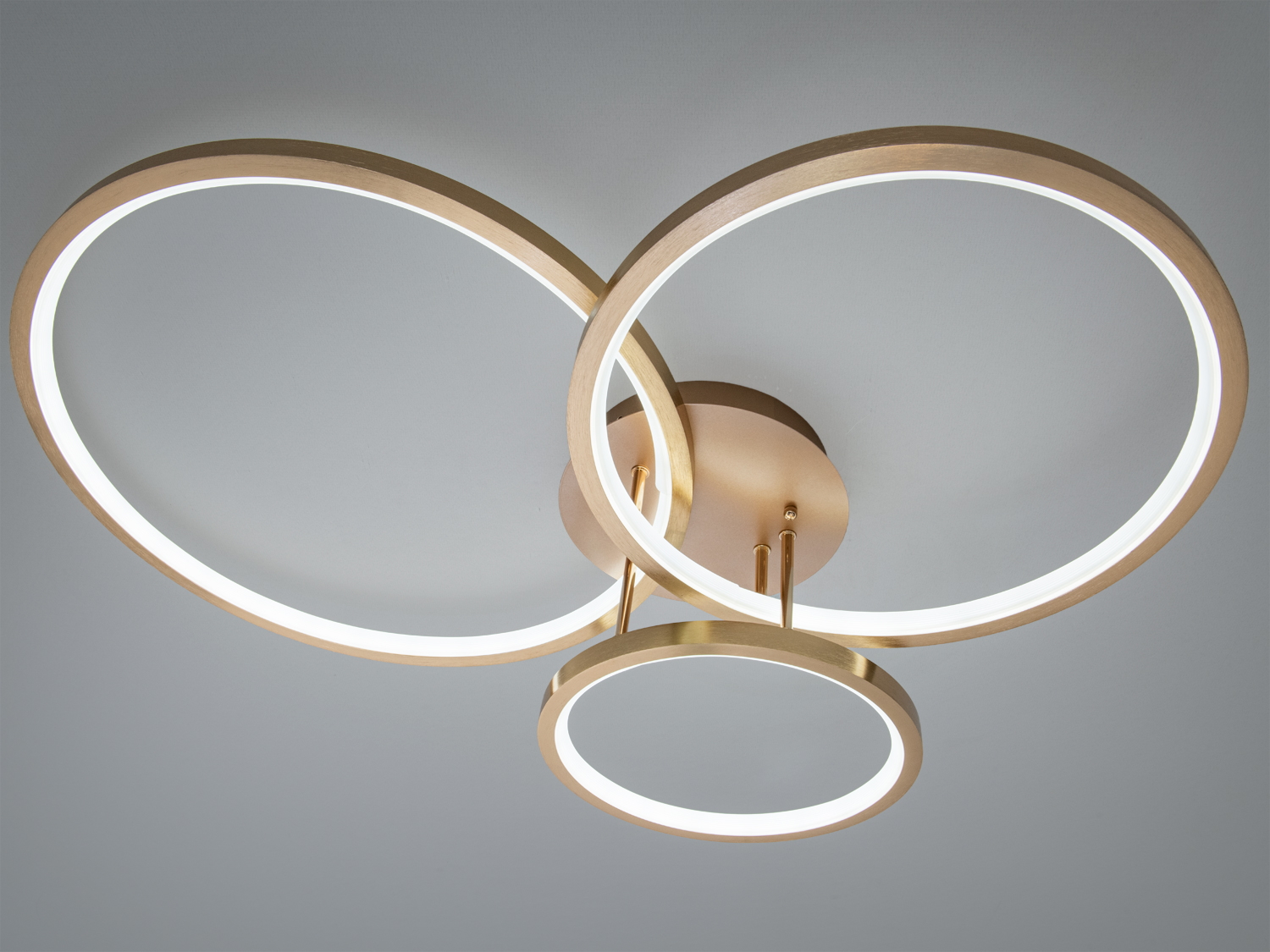 Стельовий світильник з трьома кільцями, що перетинаються, з матового золота. Призначений для монтажу на стелю, ідеально підходить для вітальні.