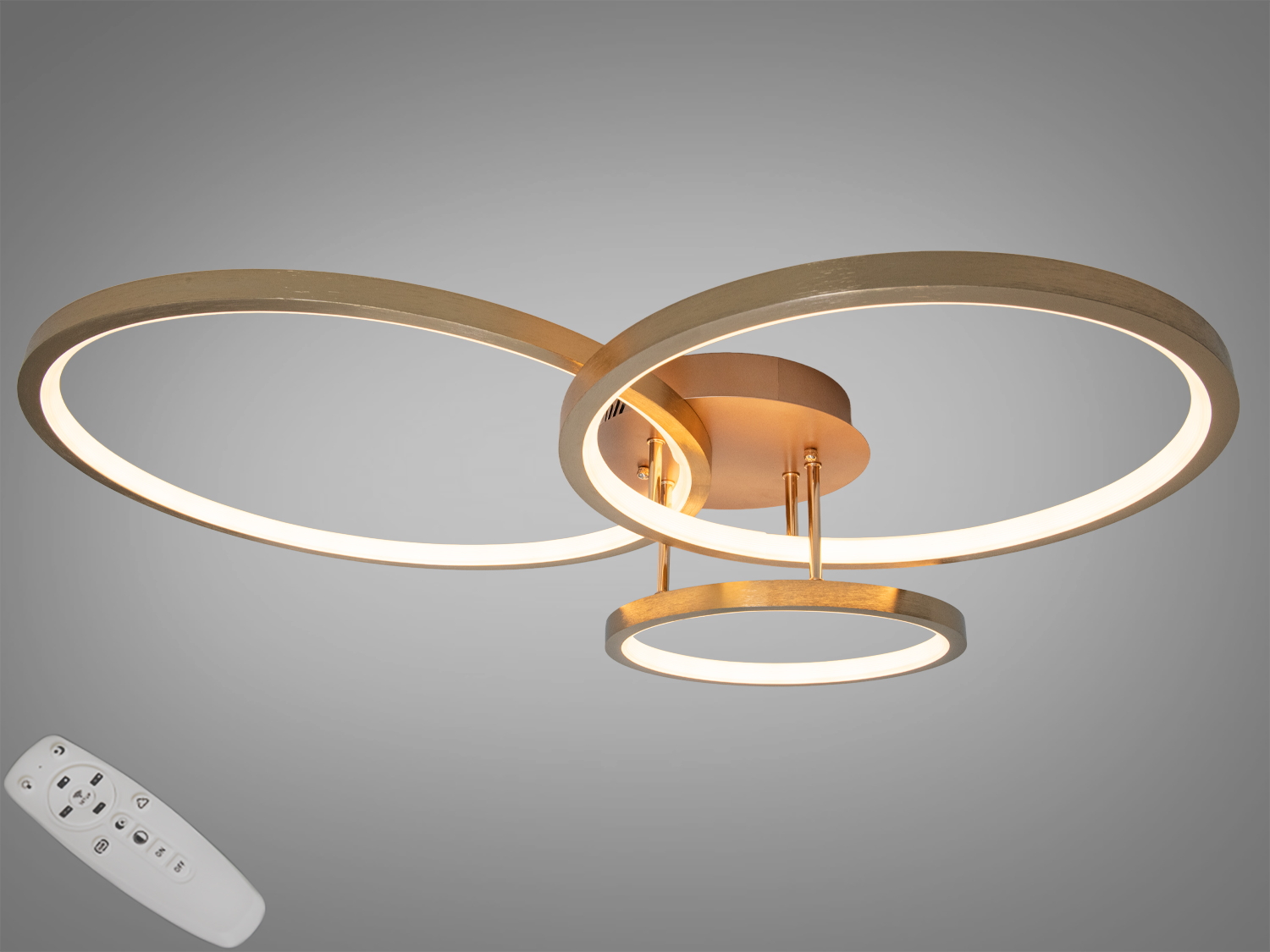 Світильник із трьома золотими кільцями, що перетинаються, з пультом дистанційного керування. Забезпечує регульоване освітлення для різних потреб.
