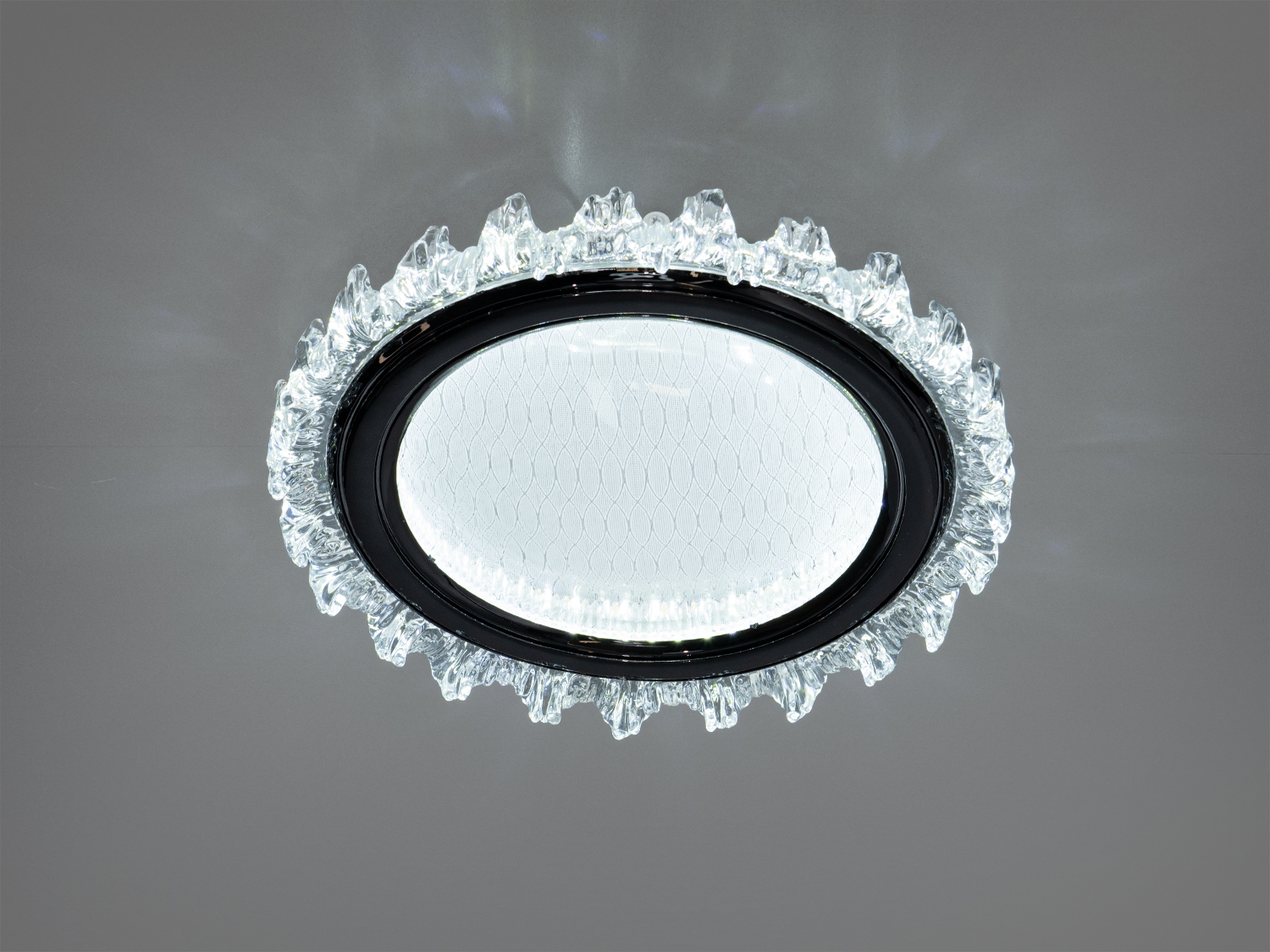 Кругла лампа з прозорим акриловим краєм і сітчастою текстурою на акрилі. Призначена для монтажу на стелі, додає елегантності приміщенню.