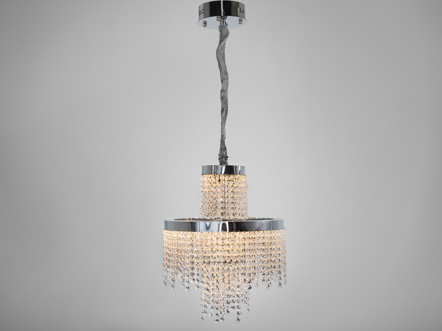 Підвісна люстра з двома ярусами кришталевих підвісок, кругла форма, хромований корпус, підходить для вітальні.