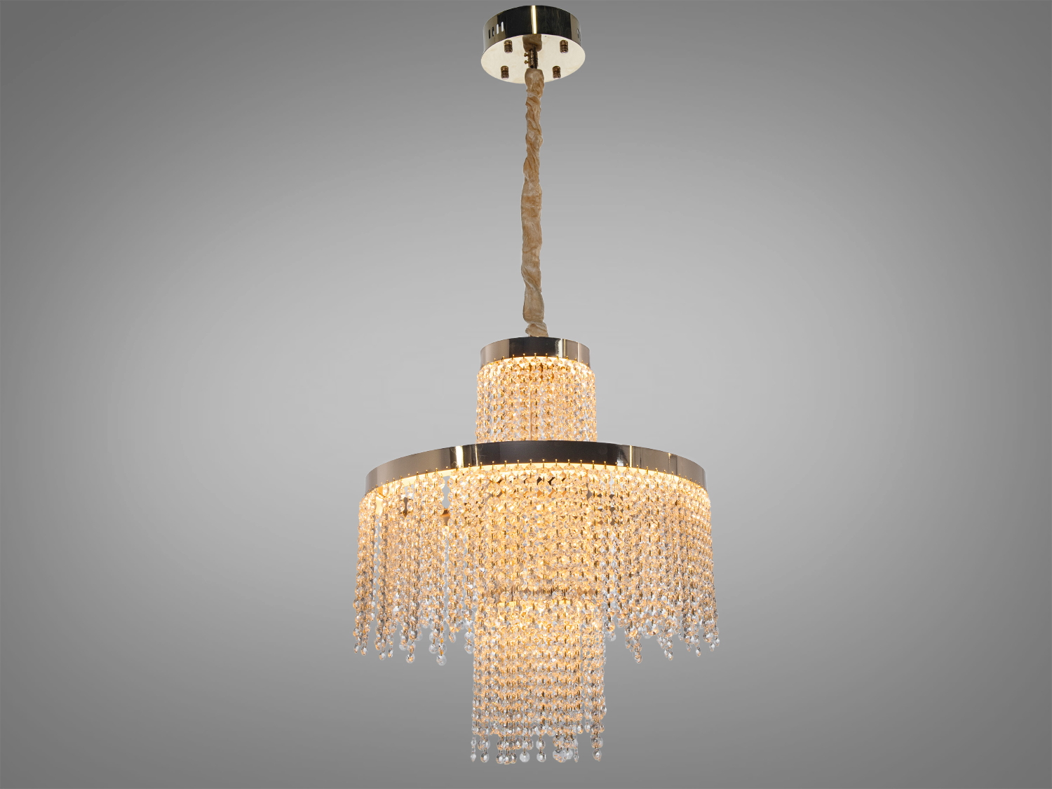 Підвісна люстра з кришталевими підвісками, кругла форма, підходить для вітальні. Металеві елементи додають сучасності.