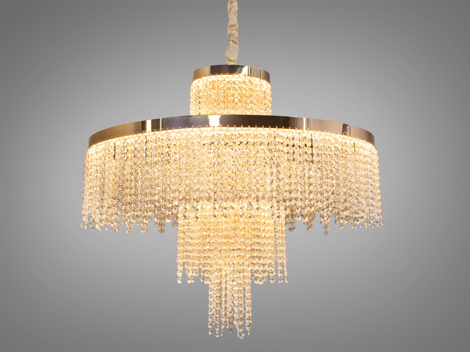 Кришталева люстра з круглою формою, прикрашена каскадними підвісками, створює розкішний акцент для вітальні.