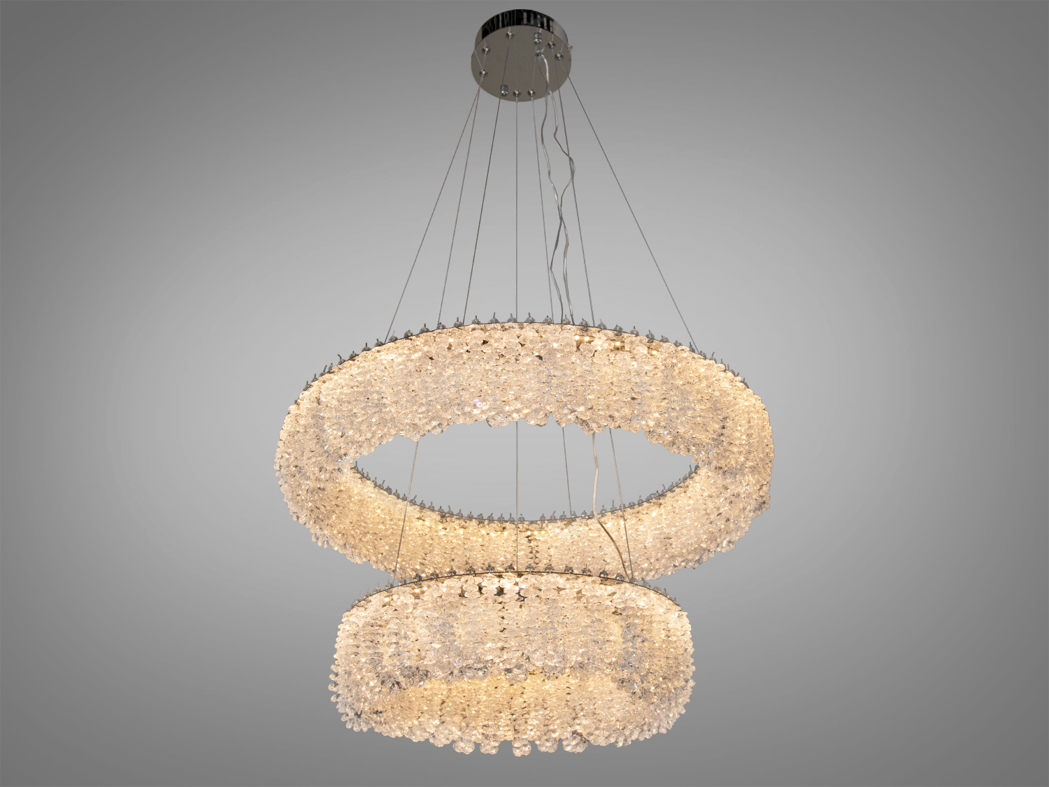 Елегантна люстра з двома кристалічними кільцями. Тепле освітлення, підходить для вітальні або їдальні.