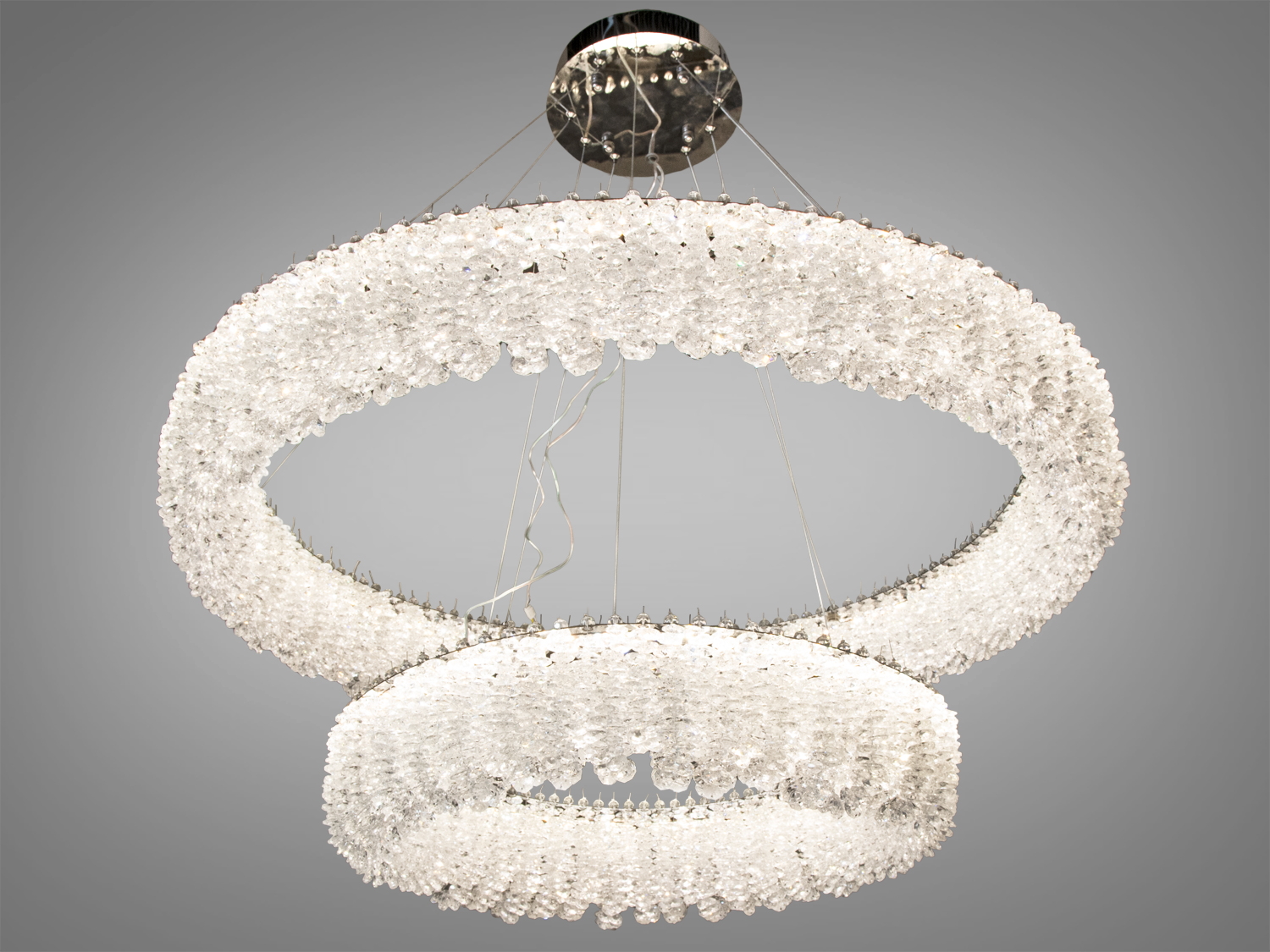 Підвісна люстра з двома кільцями, прикрашеними кристалами, створює ефектний світловий акцент у сучасному інтер’єрі.