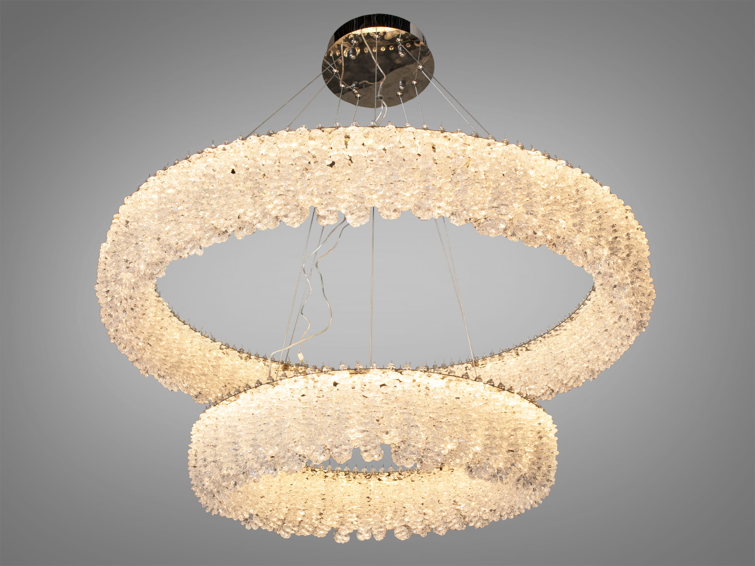 Люстра з теплим світлом, що відбивається від кришталевих елементів, ідеальна для затишних вечорів у вітальні.