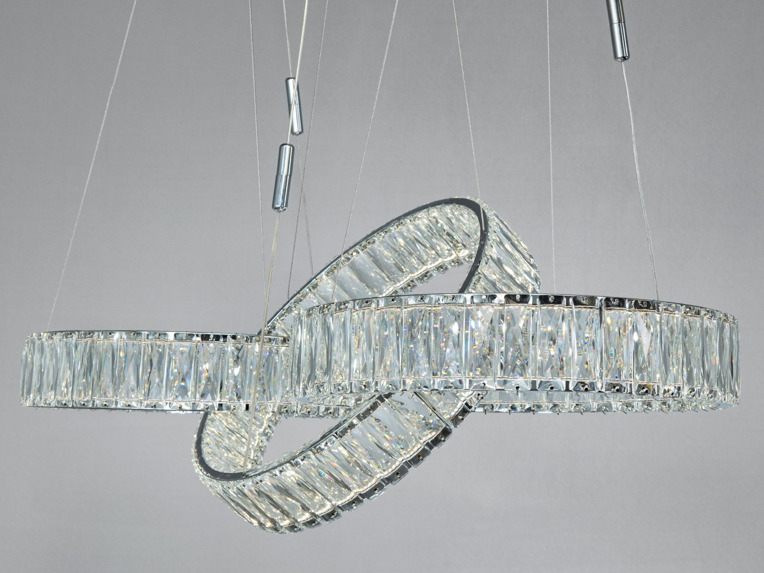 Блискуча люстра з трьома кришталевими кільцями, що перетинаються, створює унікальний світловий ефект. Ідеально підходить для сучасного інтер′єру.