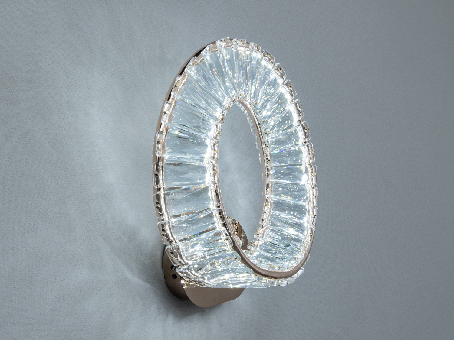 Круглий світильник з прозорими елементами, що відбивають світло, підходить для сучасних інтер’єрів.