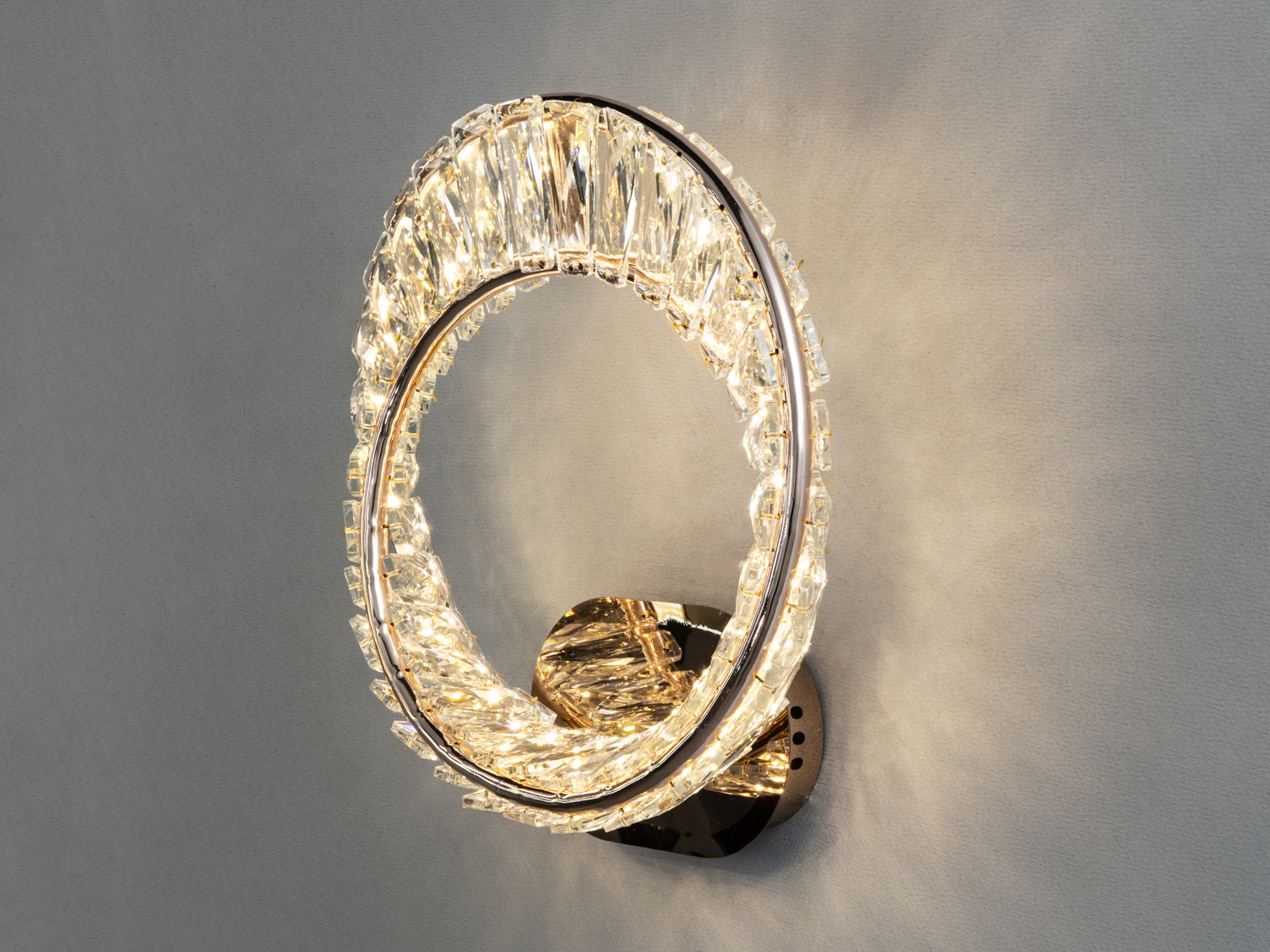 Настінний світильник з кристалічними деталями, що створює м’яке освітлення, ідеальний для віталень.