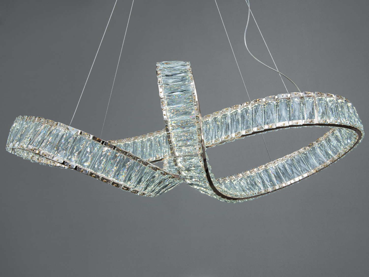 Люстра з кришталевими вставками, що створюють ефект хвилі. Підвісна конструкція на тонких дротах.