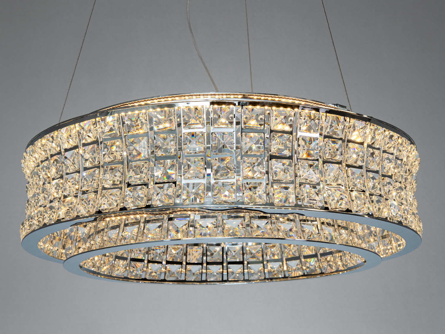 Кругла люстра з кристалами, що відбивають світло. Підходить для монтажу на стелі в просторих кімнатах.