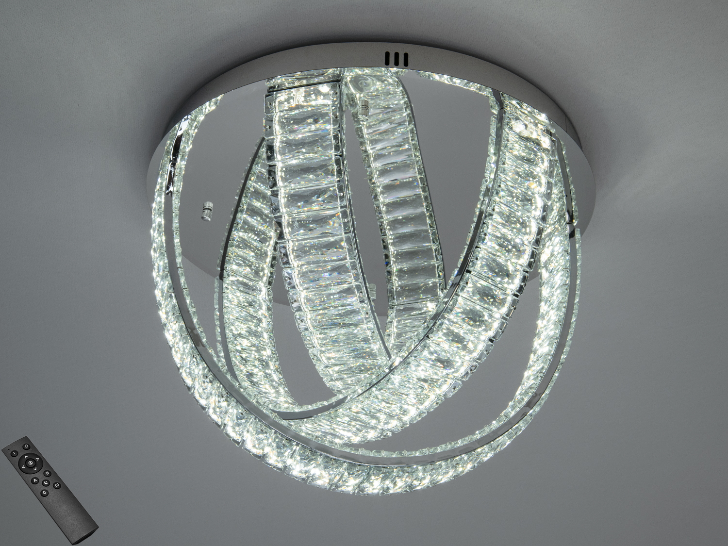 Світильник з дистанційним керуванням, що має кристалічні кільця. Підходить для стельового монтажу в сучасних приміщеннях.