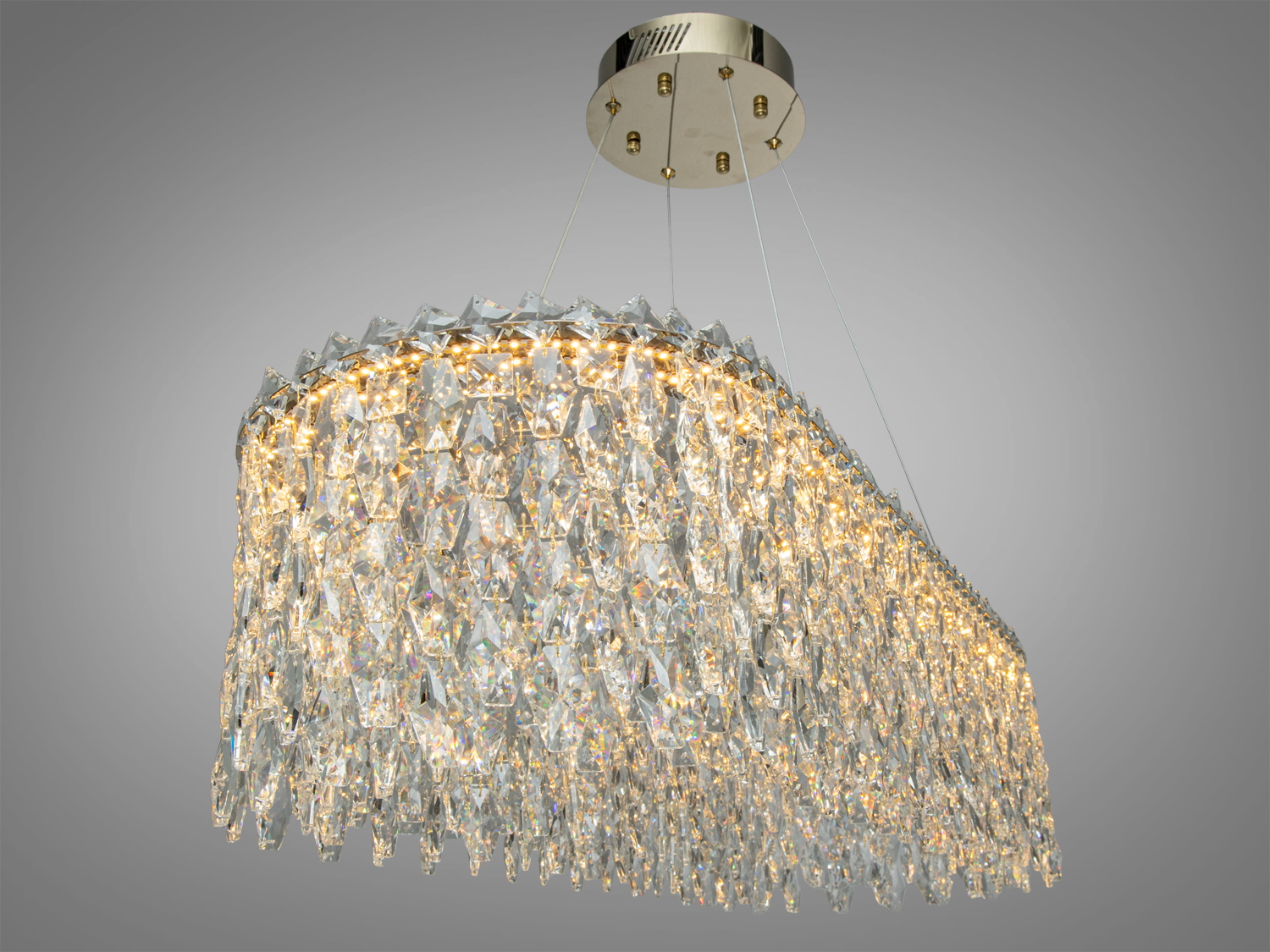 Кришталевий світильник з теплим світлом, підвішений на тонких тросах, підходить для вітальні.