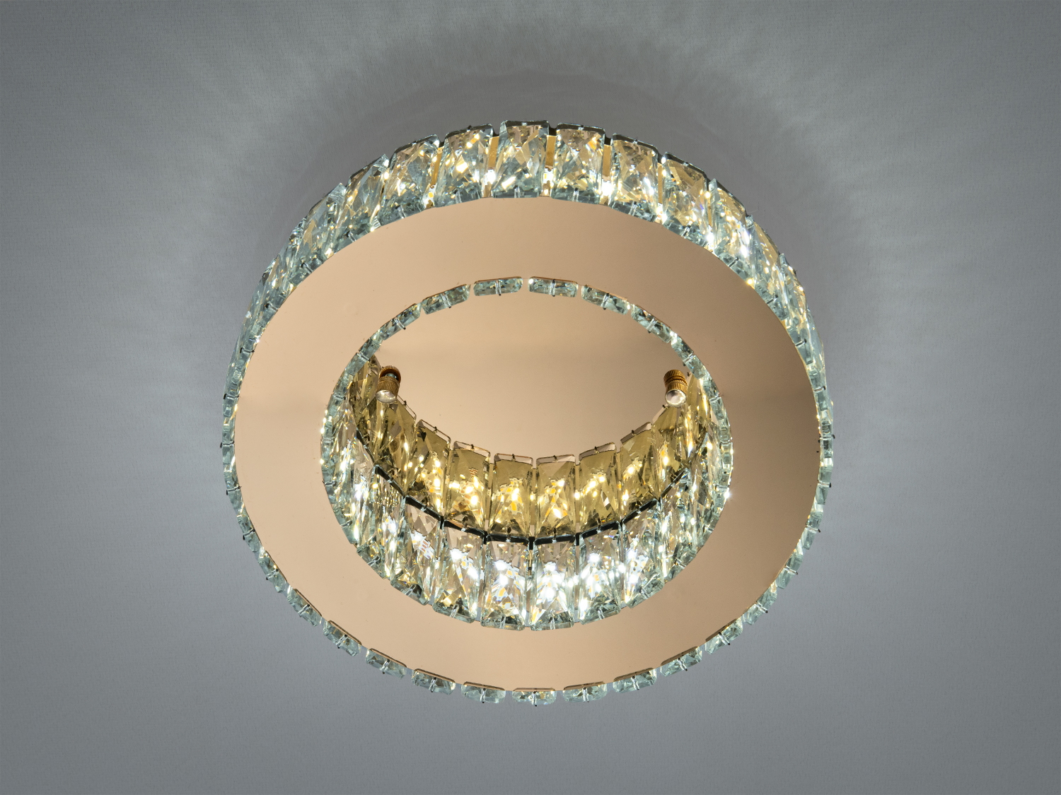 Кругла стельова люстра з кришталевими елементами, що створюють ефект сяйва. Підходить для вітальні або спальні.