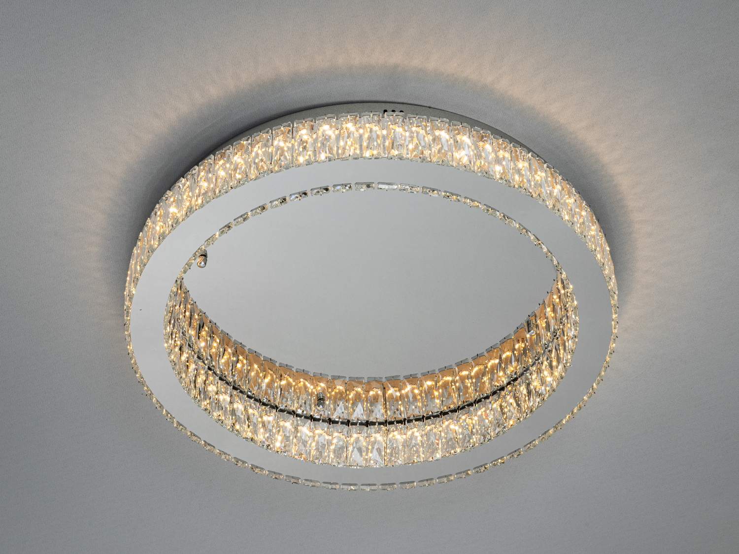 Кругла стельова люстра з кришталевими елементами, що створюють м’яке розсіяне світло. Ідеально підходить для сучасного інтер’єру.