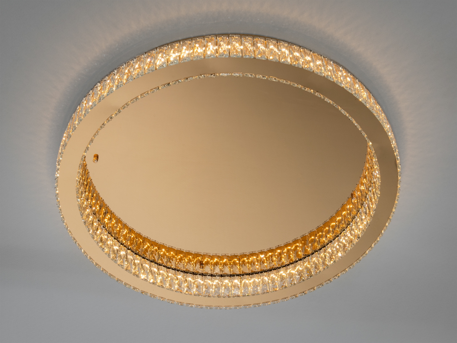 Кругла стельова люстра з кришталевими вставками, що забезпечують розсіяне світло. Ідеально підходить для сучасних інтер’єрів.