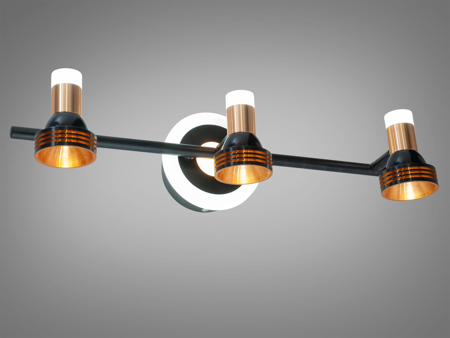 Триламповий світильник з круглою основою, чорний з мідними та золотими деталями. Використовується для освітлення сучасних приміщень.