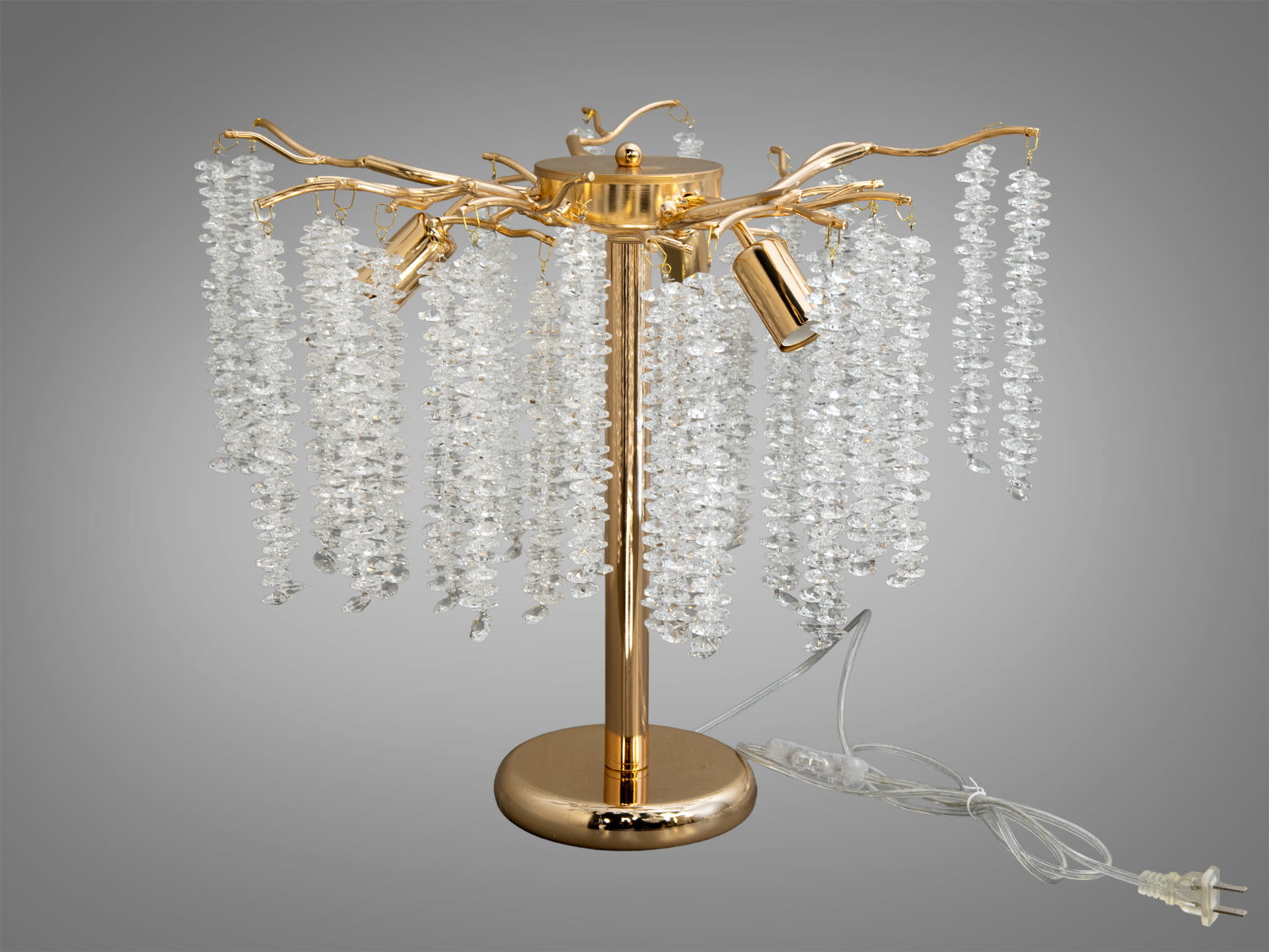 Настільна лампа з кришталевими підвісками, що нагадують водоспад. Золотистий каркас надає елегантності, підходить для вітальні.