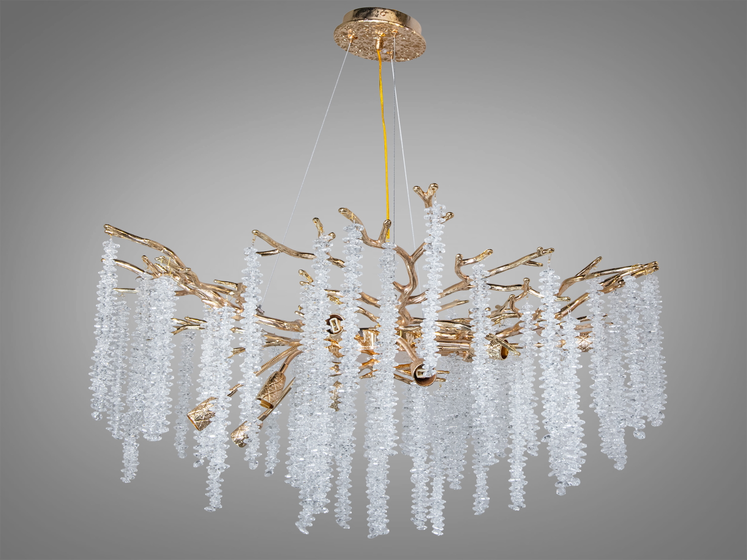 Підвісна люстра з кришталевими підвісками та золотистою основою, що нагадує гілки дерева. Ідеальна для вітальні з високими стелями.