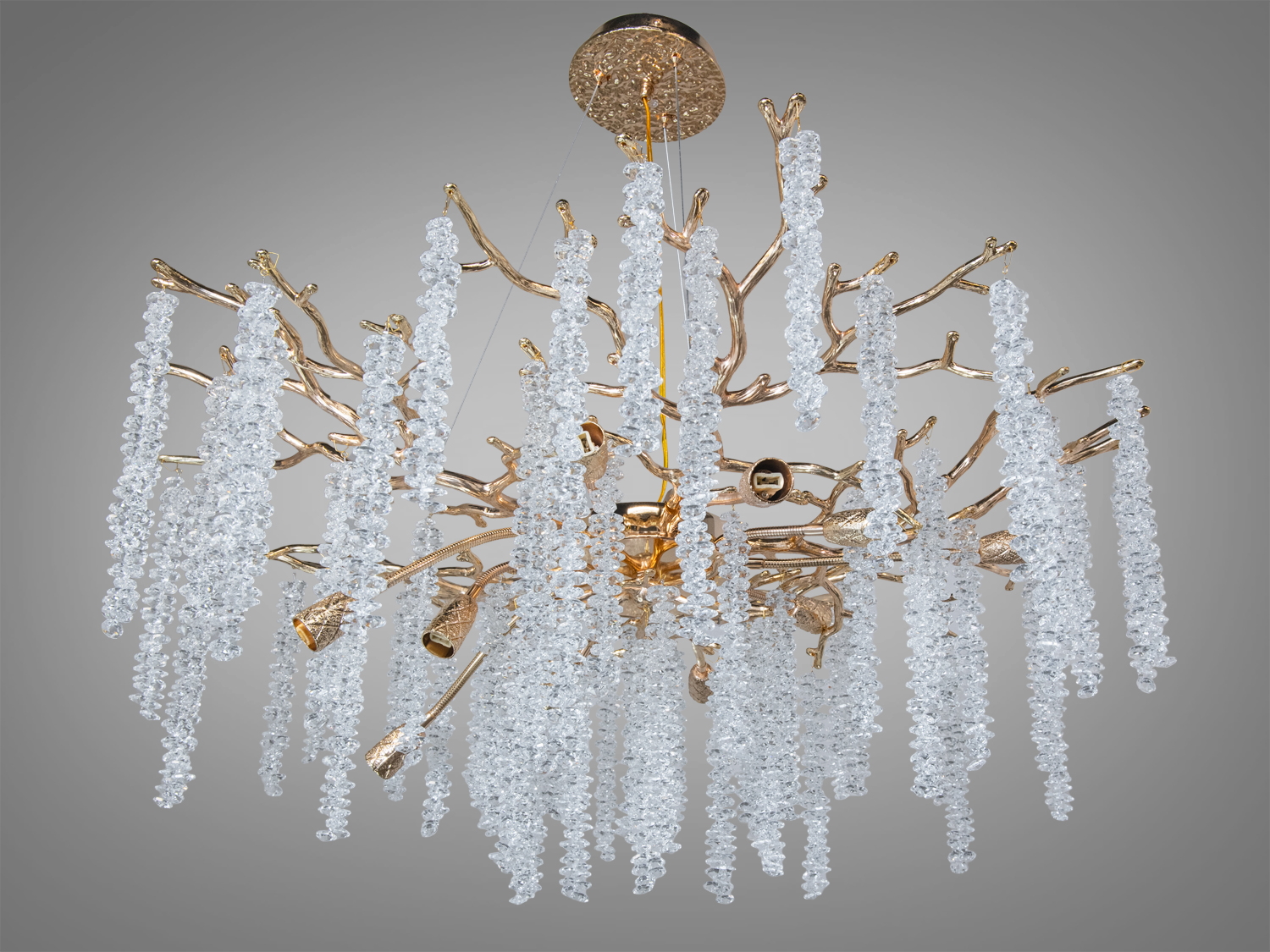 Елегантна люстра з кришталевими підвісками, що нагадують бурульки, на золотистій основі. Підходить для просторих приміщень.