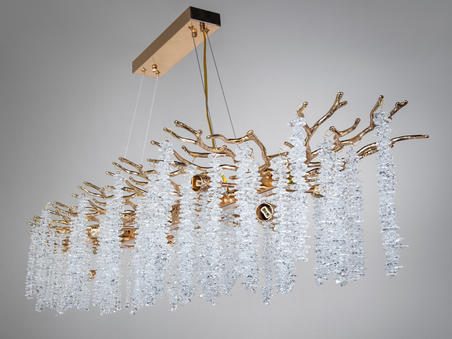Елегантна люстра з кришталевими підвісками на золотистій основі, що створює ефект водоспаду. Ідеальна для розкішного інтер′єру.