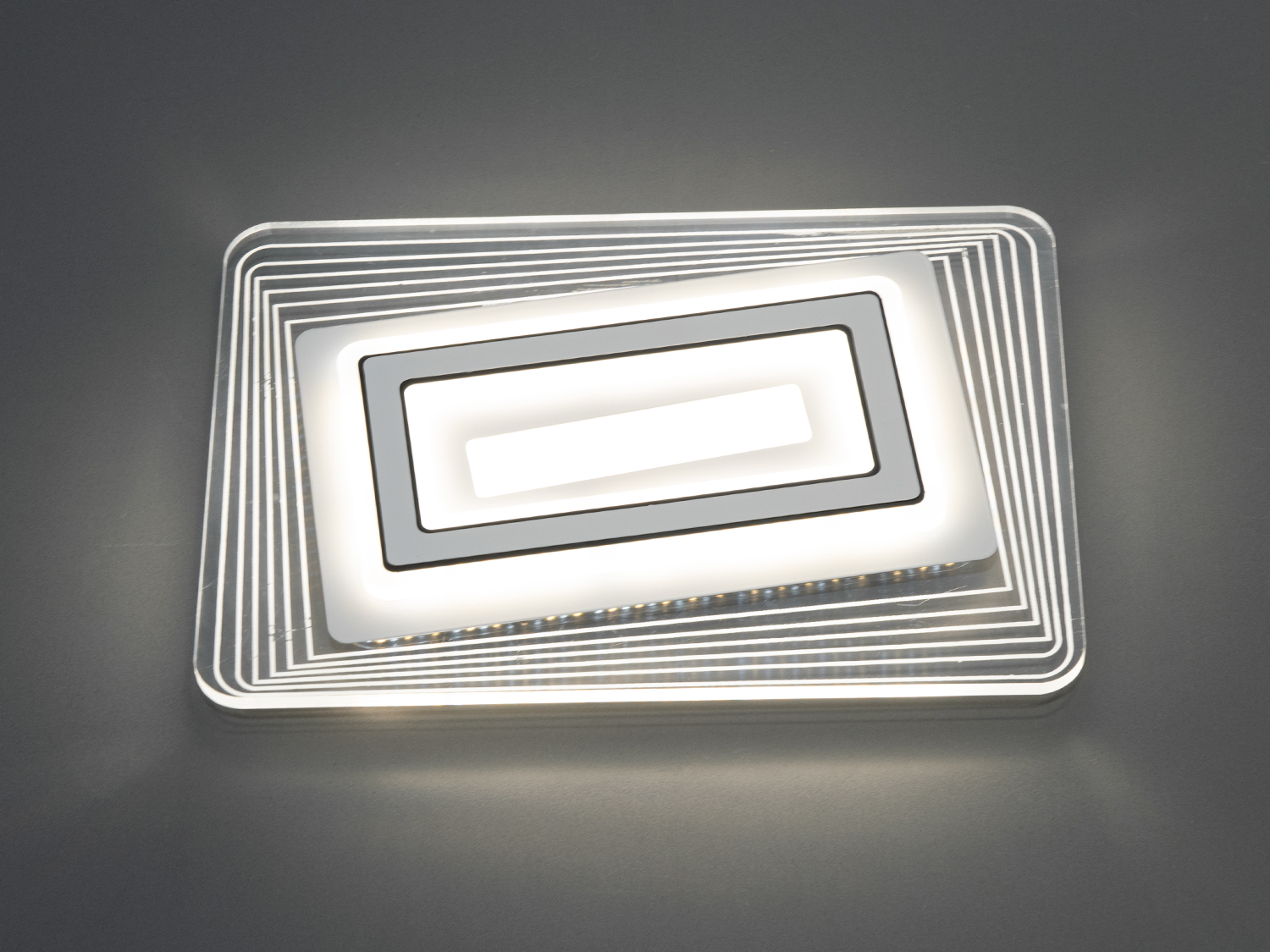 Стельовий світильник з прозорими акриловими елементами, що створюють ефект об’ємності. Ідеальний для офісних приміщень.