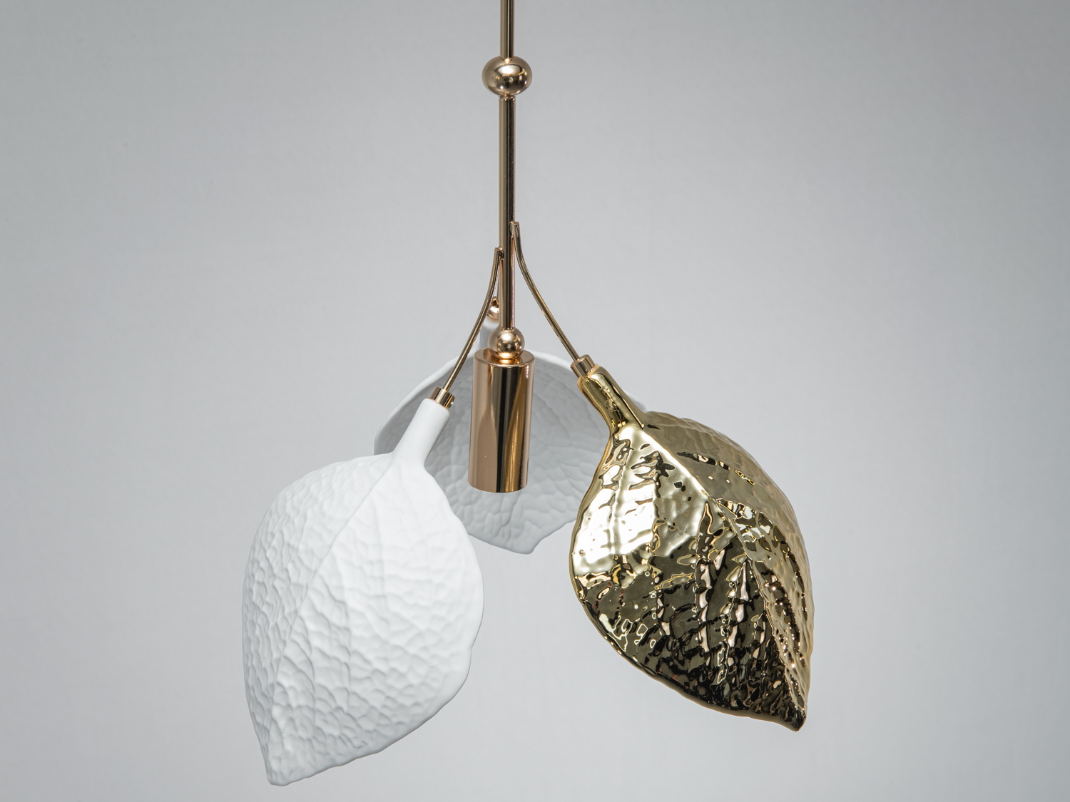 Деталь підвісного світильника з білими та золотими листками, підходить для вітальні.