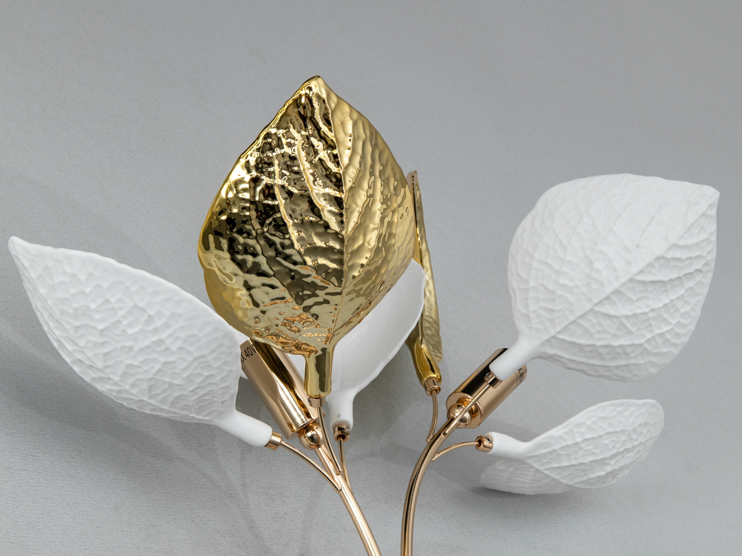 Світильник із металевими листками, золотий та білий дизайн. Використовується для настінного освітлення, створює природний акцент в інтер’єрі.