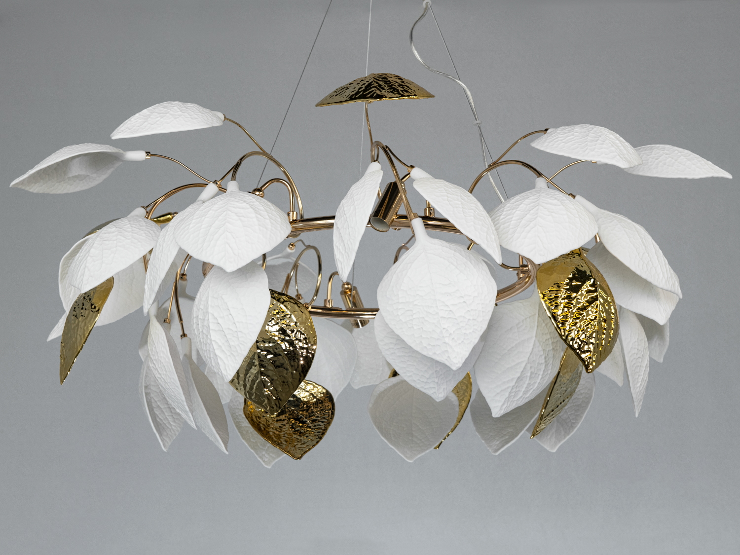 Люстра з білими та золотими листками, виготовленими з металу, що підкреслюють елегантність. Ідеальна для вітальні.