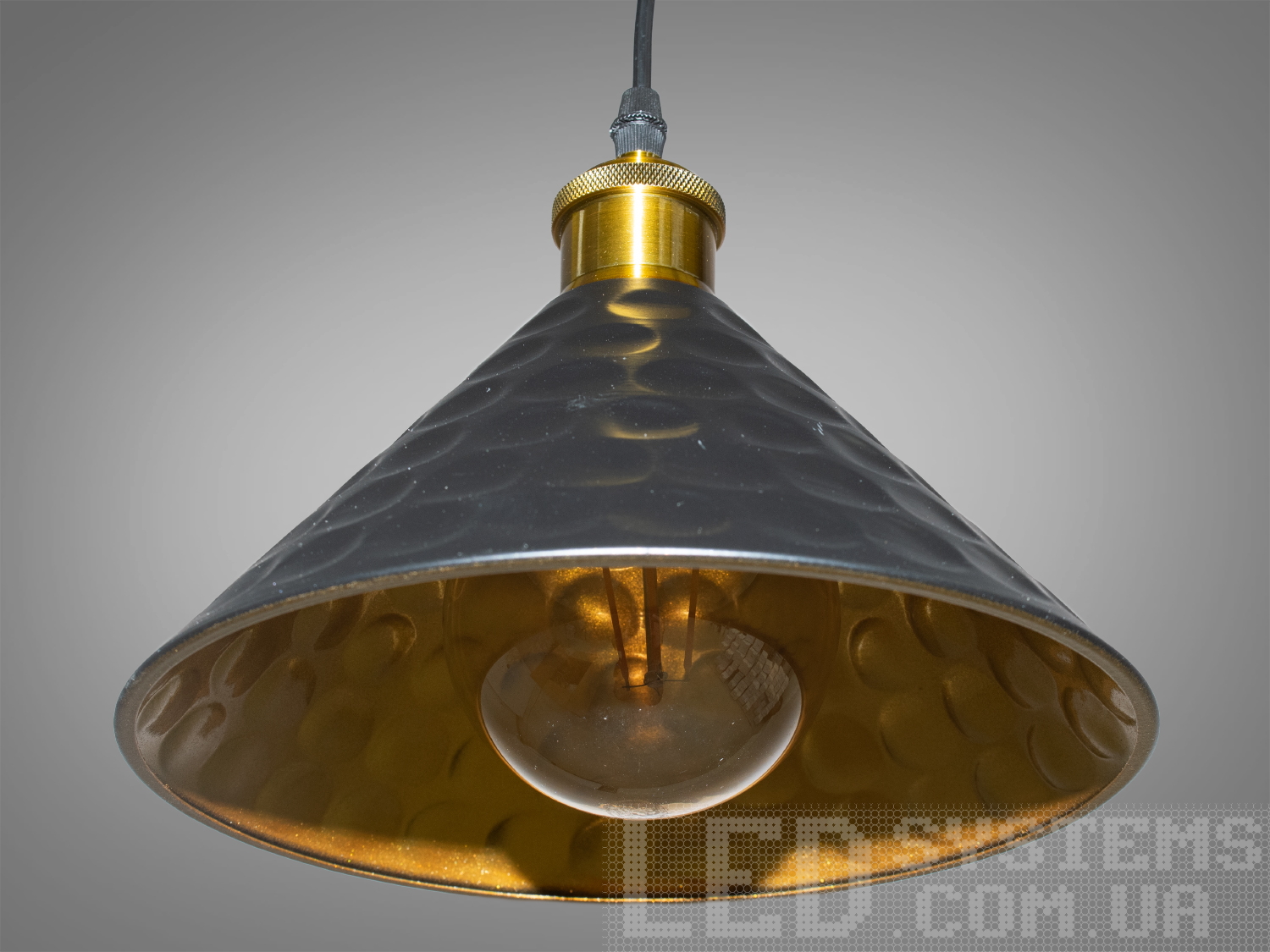 Світильник-підвіс в стилі лофт, який ідеально підходить під лампочку Едісона, об'єднує  у собі вишуканість  та  індустріальний шарм. Його дизайн підкреслює автентичність та теплоту лампочки Едісона, створюючи унікальний елемент декору та освітлення.
Характеристики світильника:
Лампа Едісона як центральний елемент: Спеціально розроблений дизайн, що виділяє та підкреслює лампу Едісона як центральний елемент світильника. Застосування лампи Едісона з декоративними нитками або нестандартною формою додає виробу вишуканості та тепла. Лампочка Едісона надає приємне приглушене світло, створюючи тепло та затишну атмосферу в місці розташування світильника.
Матеріали з індустріальним виглядом: Використовуються металеві або чорні матеріали, що надають індустріальний шарм та вишуканість. Мінімалізм цього світильника підкреслить вашу індивідуальність і відчуття стилю. Металеві елементи можуть мати сліди старіння, підряпини чи інші недоліки, що є характерними для стилю лофт та надають світильнику виразний вигляд.
Лофтовий дизайн: З підвісом у вигляді ланцюга чи троса, грубими металевими деталями та відкритим дизайном, що додає стиль лофту. Стиль «Лофт» зараз дуже популярний, його люблять як творчі особистості, так і вельми практичні люди, які віддають перевагу комфорту і простоті в інтер'єрі. Світильники в стилі «лофт» ідеально впишуться в сучасні будинки, квартири, кафе, арт-простори, коворкінги, квеструми.
Підвісний світильник ідеально поєднується з іншими індустріальними деталями, такими як відкриті труби, цегла або металеві стільниці.
Можливість регулювання висоти: Дозволяє легко адаптувати світильник до різних просторових умов.
Сфери використання:
Ресторани та кафе: Створює тепло та затишне освітлення, ідеально підходить для створення атмосфери в зонах обіду або бару.
Житлові приміщення: Виглядає чудово у вітальнях, кухнях чи спальнях, додаючи індустріальний акцент до інтер'єру.
Магазини та виставкові зони: Створює стильний вигляд для приміщень, де важливий дизайн та видиму привабливість. Вигідно підкреслює стильні товари або предмети мистецтва, надаючи їм індивідуальний вигляд.
Фото- та відеостудії: Забезпечує освітлення з характером для створення унікальних фото чи відеоматеріалів.
Цей світильник-підвіс у стилі лофт з лампочкою Едісона створює особливу атмосферу, де тепло та стиль індустріального дизайну взаємодіють, надаючи приміщенню унікальний і вишуканий вигляд.
Лампа в комплект не входить.