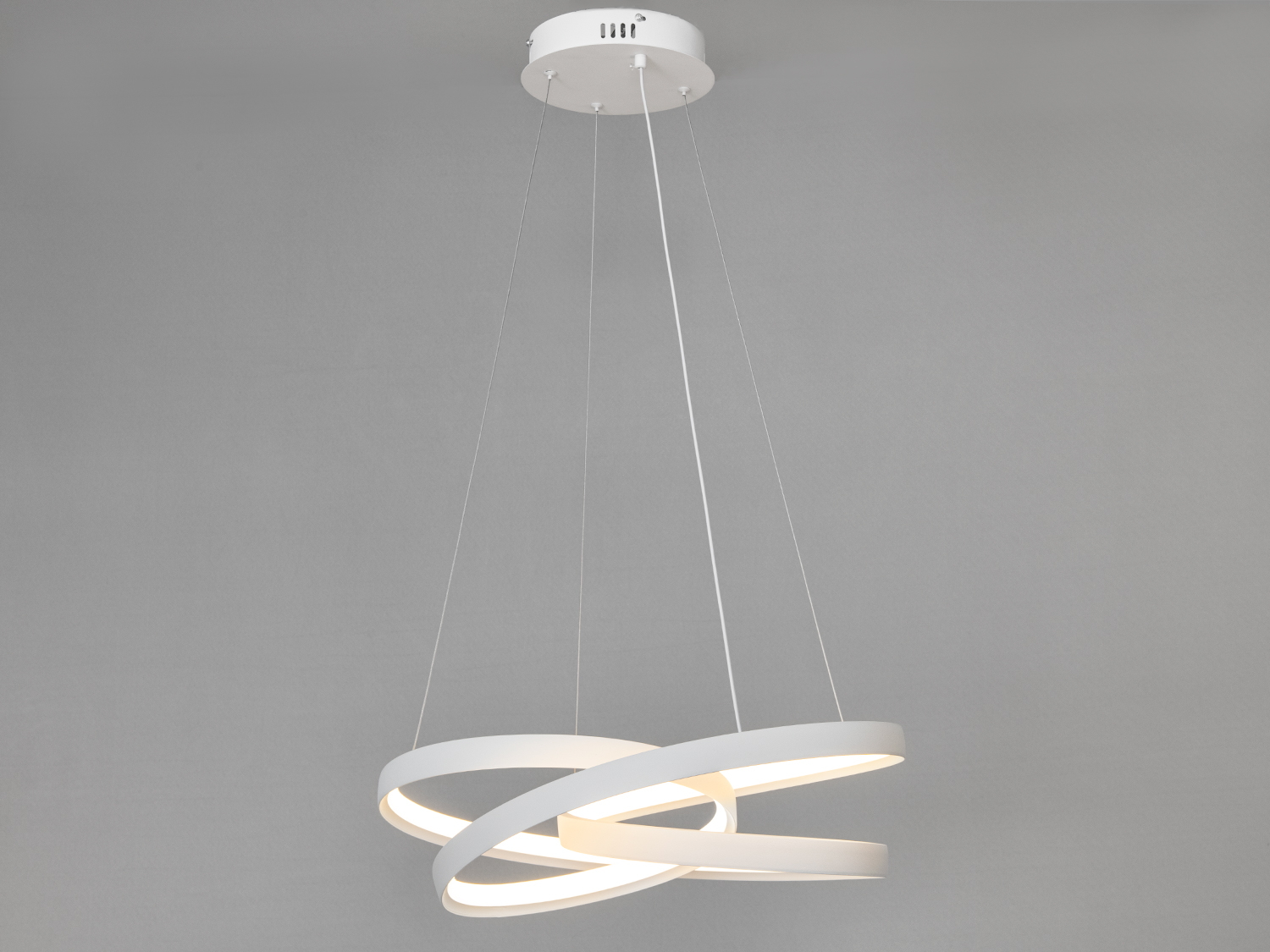 Люстра включена, демонструє мяке біле світло, яке ефектно підкреслює переплетення форм.