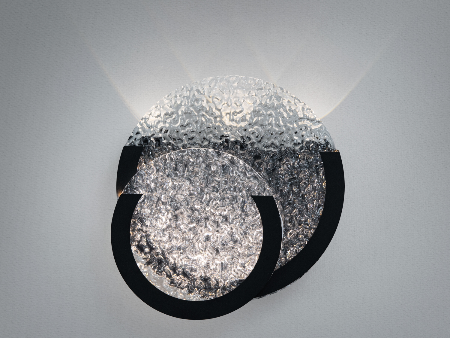 Настінний світильник із текстурованого скла, що створює м’яке розсіяне світло. Чорна металева основа додає сучасного вигляду.