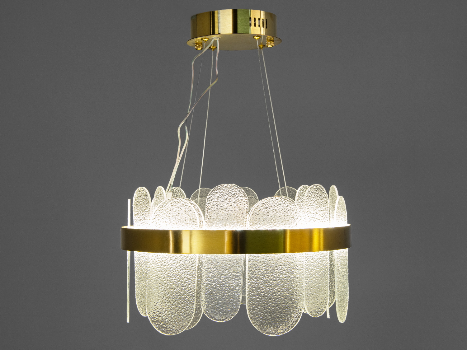 Люстра з елементами з текстурованого скла, підвішена на тонких дротах, має золотистий обідок, ідеальна для вітальні або їдальні.