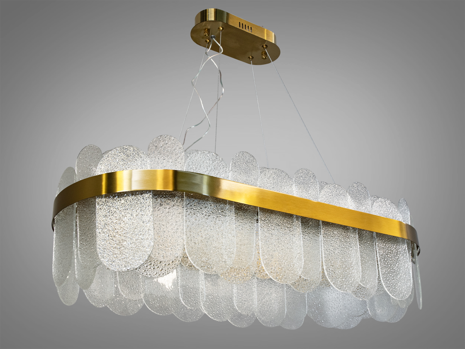 Підвісна люстра з прозорими скляними панелями овальної форми, закріпленими на металевій основі золотистого кольору.