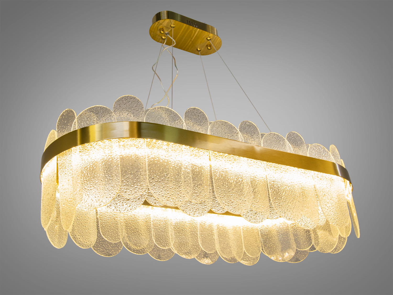 Підвісна люстра з текстурованими скляними панелями, що створюють тепле світло, підходить для вітальні або їдальні.