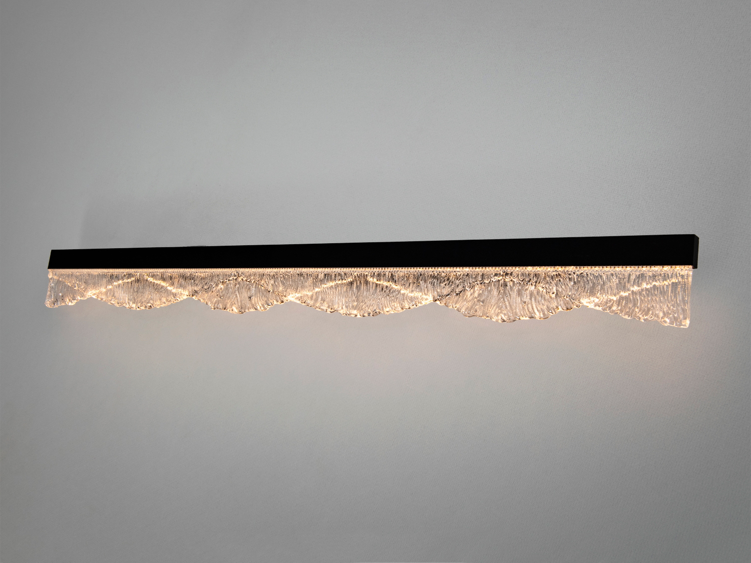 Настінний світильник з хвилястим скляним елементом, що підсвічується зсередини. Ідеальний для освітлення коридорів або віталень.