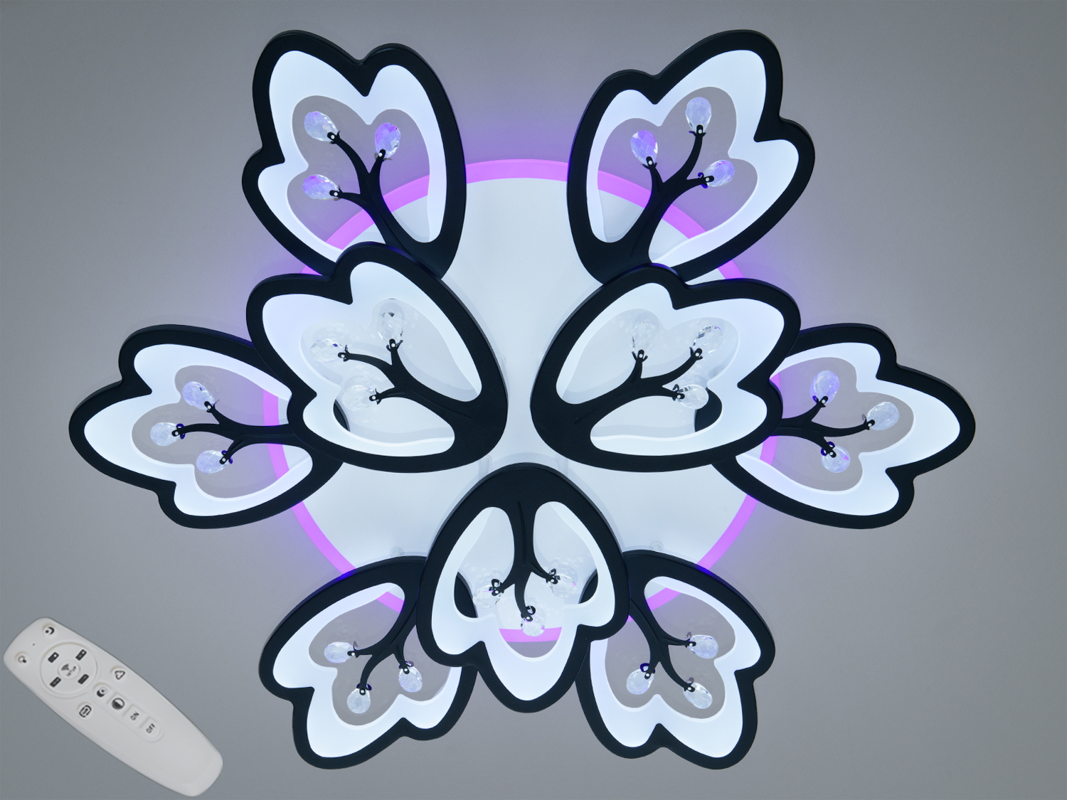 Стельовий світильник з дистанційним керуванням, має форму квітки з чорними елементами та фіолетовим підсвічуванням.