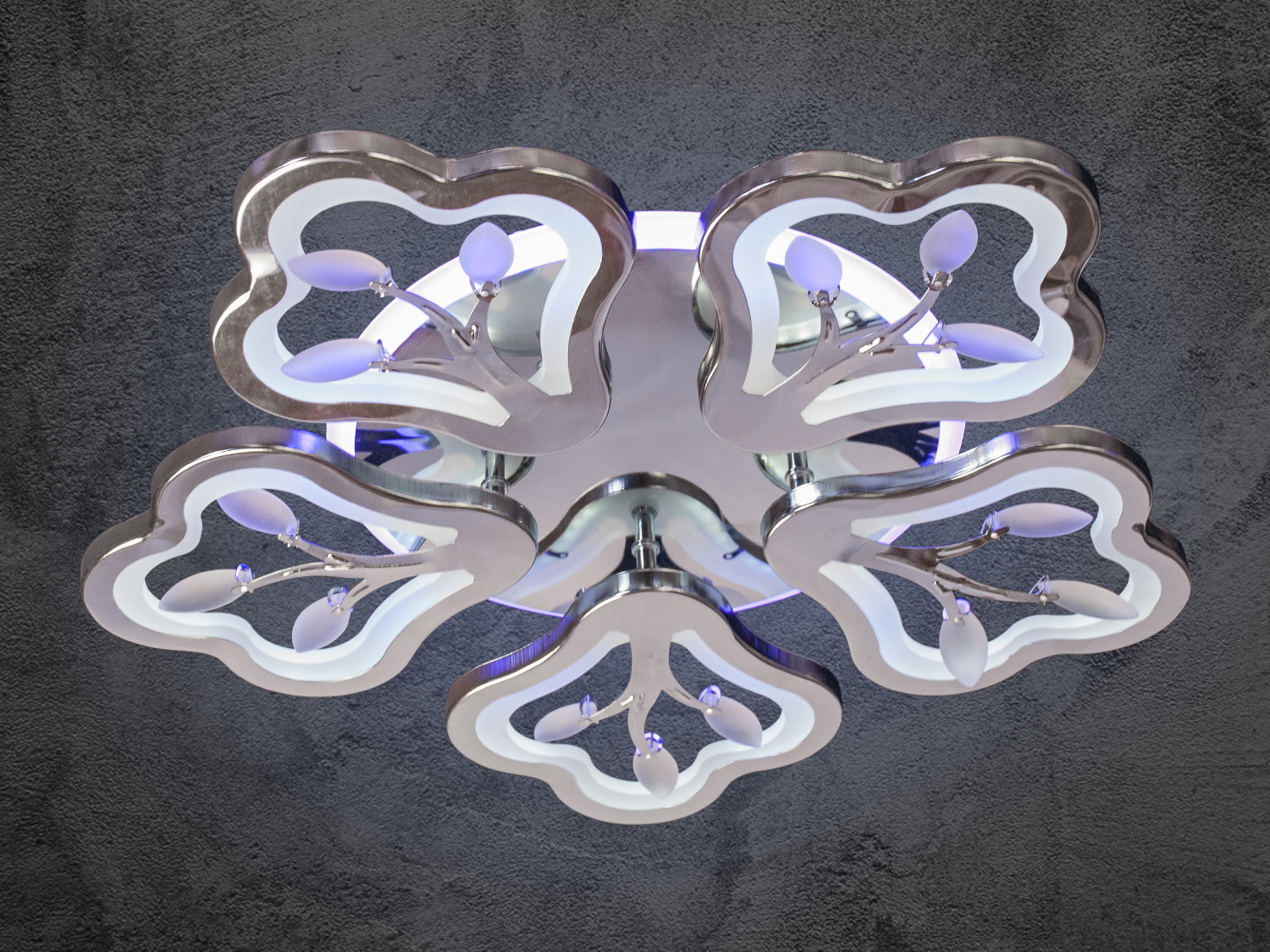 Металева люстра з п’ятьма абажурами у формі квітів, з білим підсвічуванням. Ідеальна для сучасного інтер’єру.