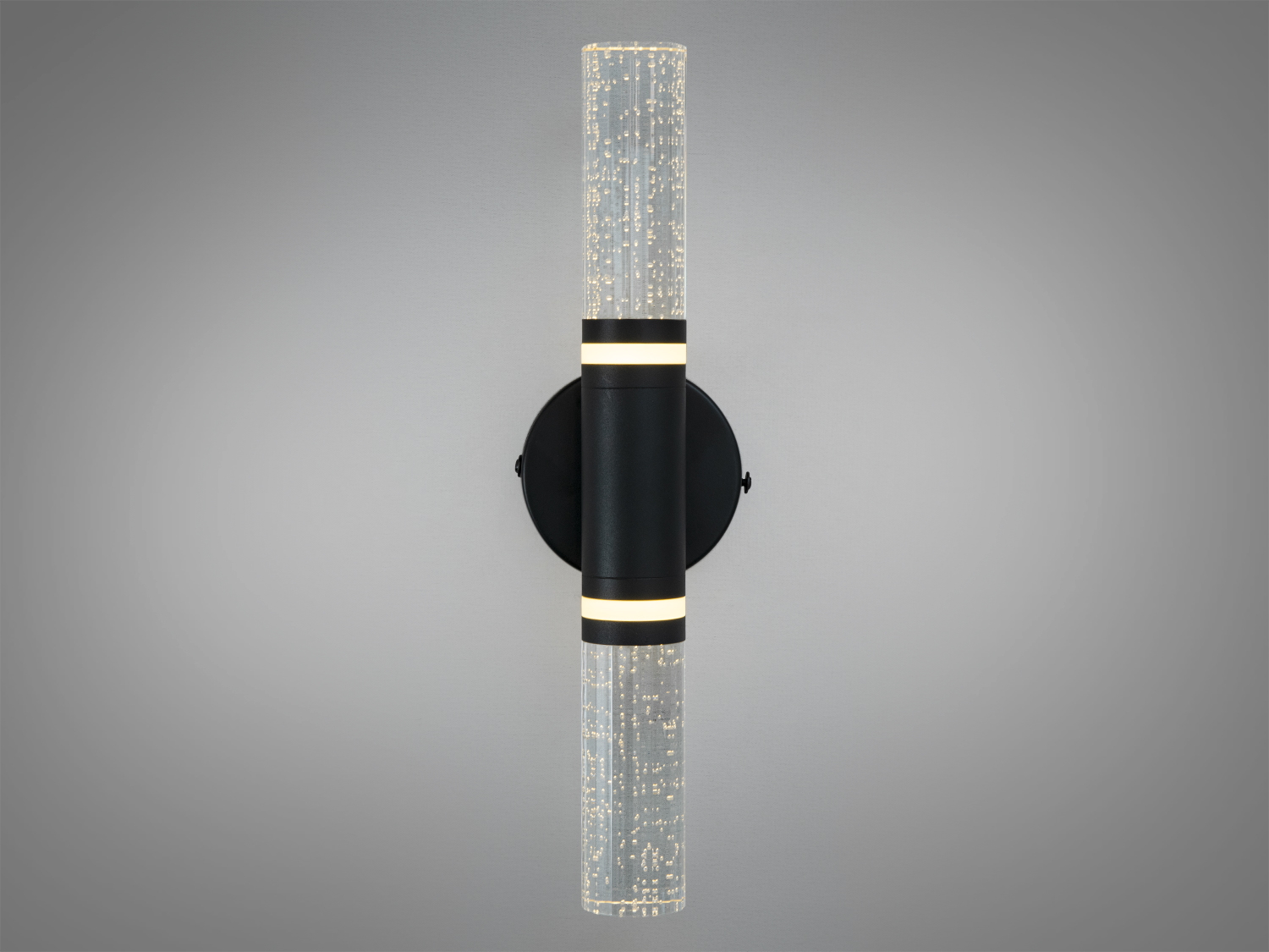 Настінний світильник з прозорими циліндричними плафонами, заповненими бульбашками. Чорна основа, підходить для сучасних інтер’єрів.