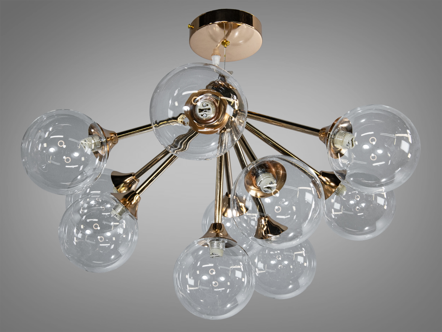 Люстра з прозорими скляними плафонами на металевих променях, золотистий відтінок. Підходить для вітальні.