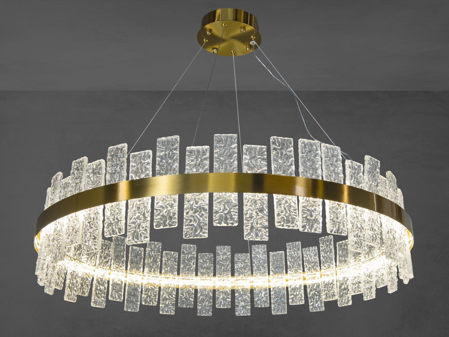 Підвісна люстра з золотистим ободом та текстурованими скляними пластинами, ідеальна для вітальні.