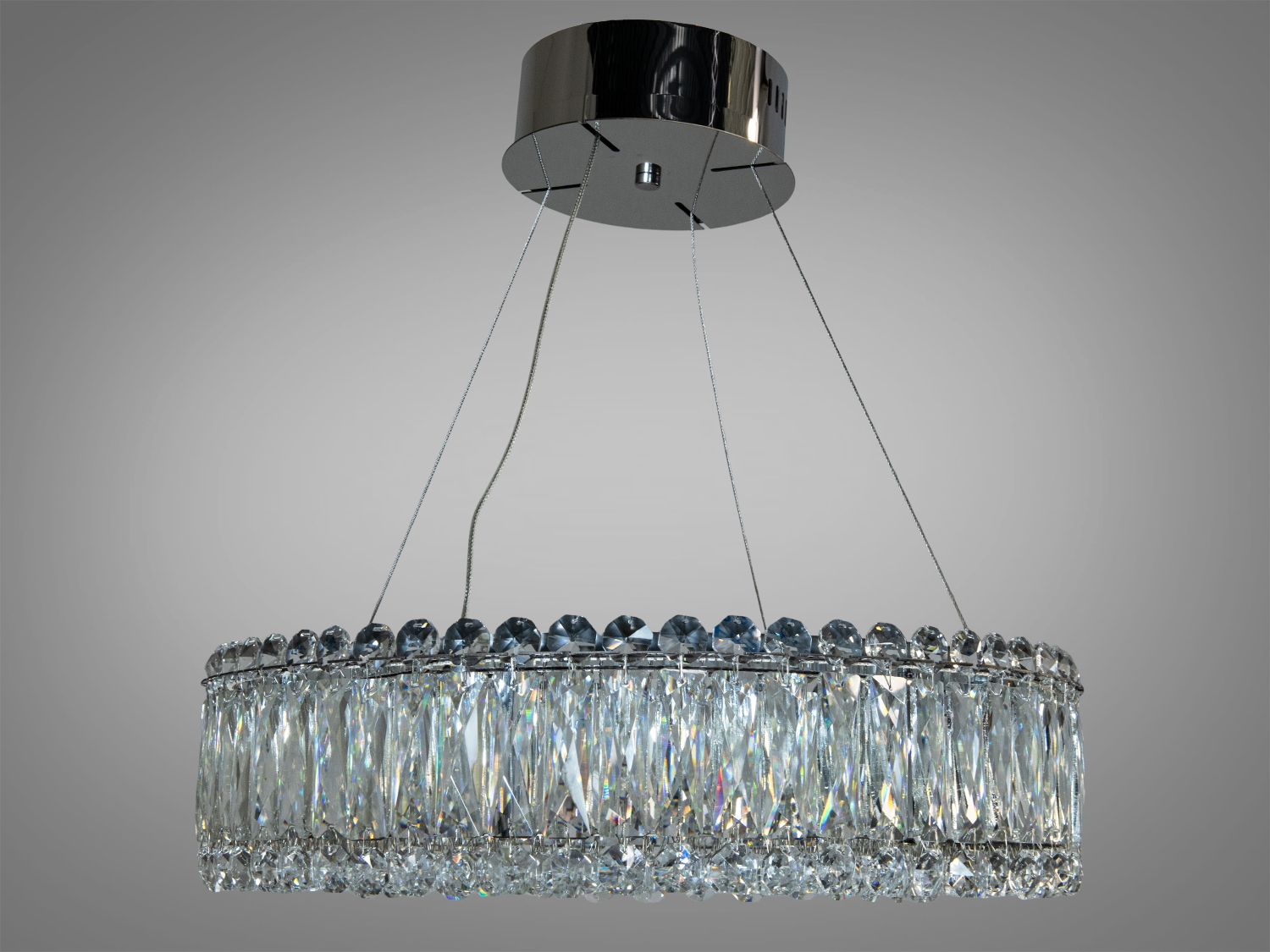 Елегантна люстра з прозорого кришталю, підвішена на металевій основі. Відмінно підходить для освітлення великих просторів.