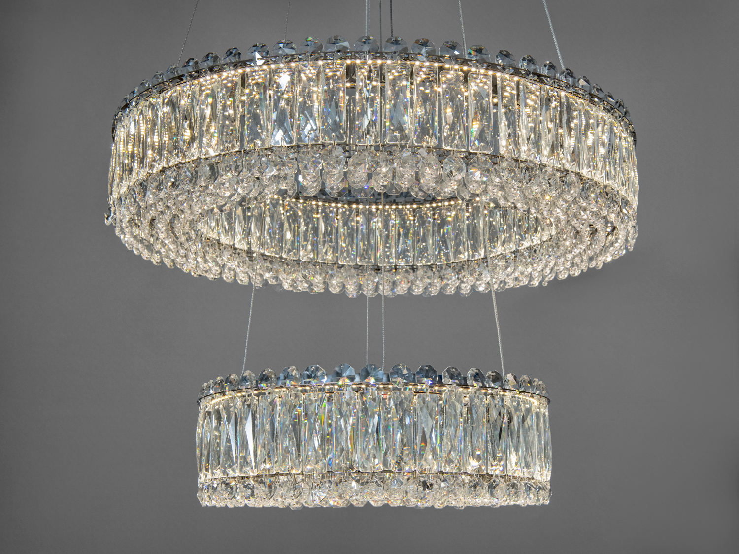 Кругла люстра з двома ярусами кришталевих підвісок. Витончений дизайн, ідеальна для сучасного інтер’єру.