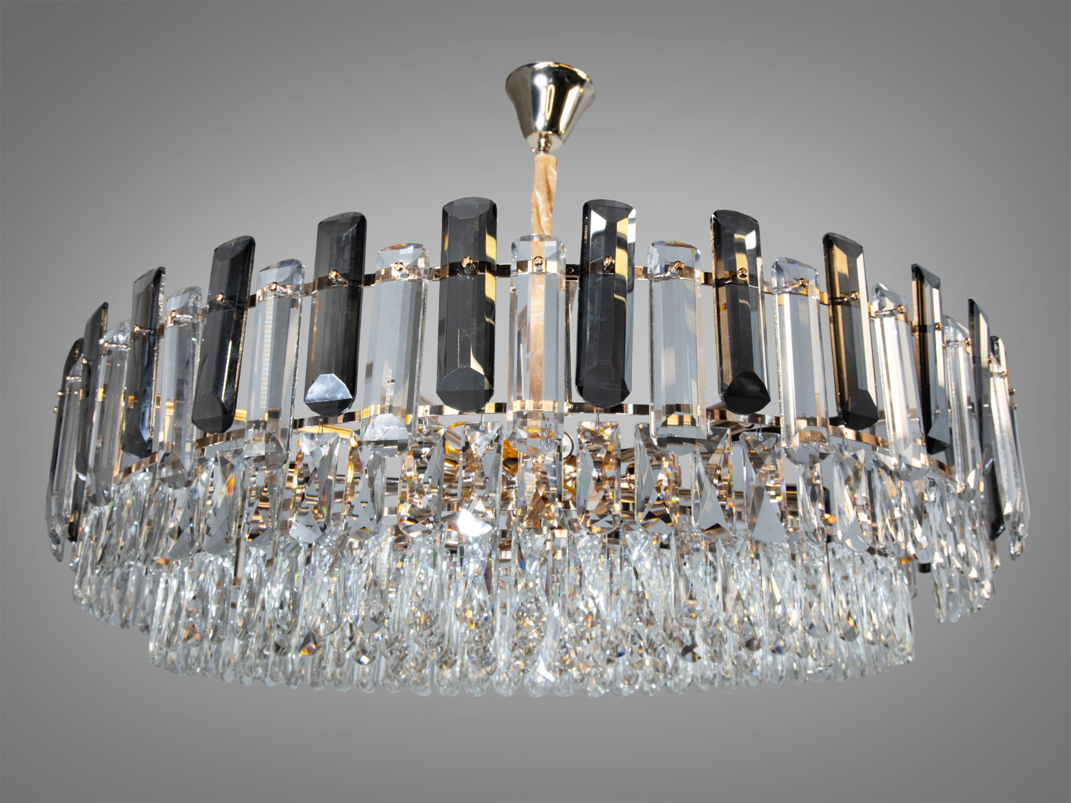 Люстра з кришталевими елементами, підвішена на металевій основі, підходить для класичних інтер’єрів.