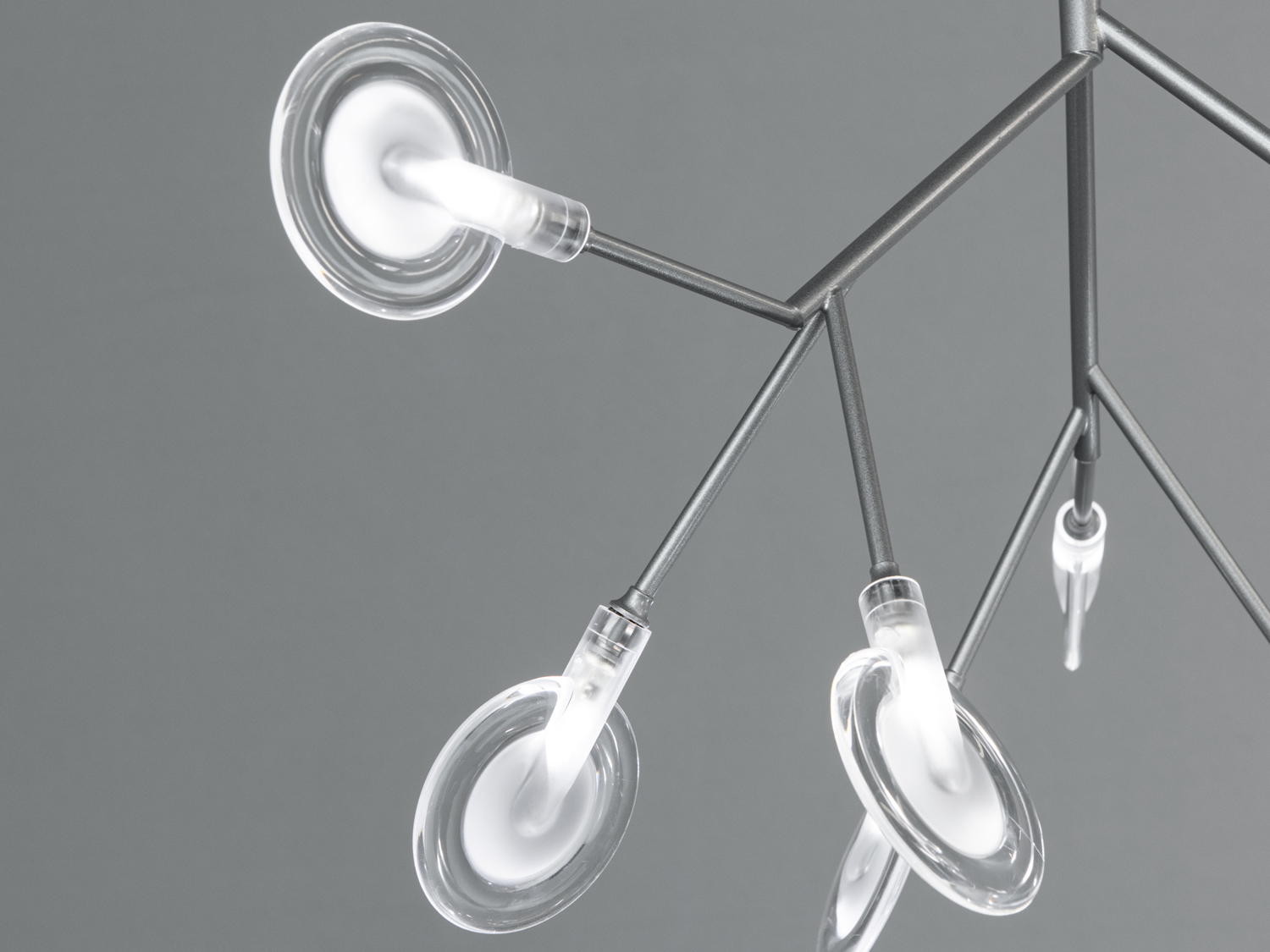 Ближній план світильника з акцентом на прозорі скляні плафони та металеві деталі. Відмінно підходить для мінімалістичного дизайну.