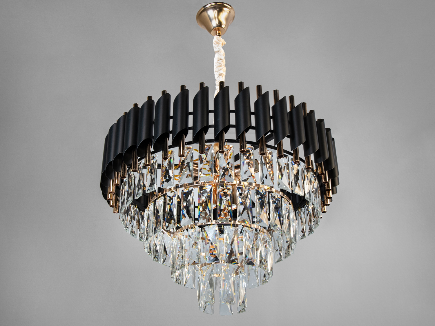 Люстра з чорними металевими елементами та кришталевими підвісками, підходить для класичних інтер’єрів, кріплення на стелі.